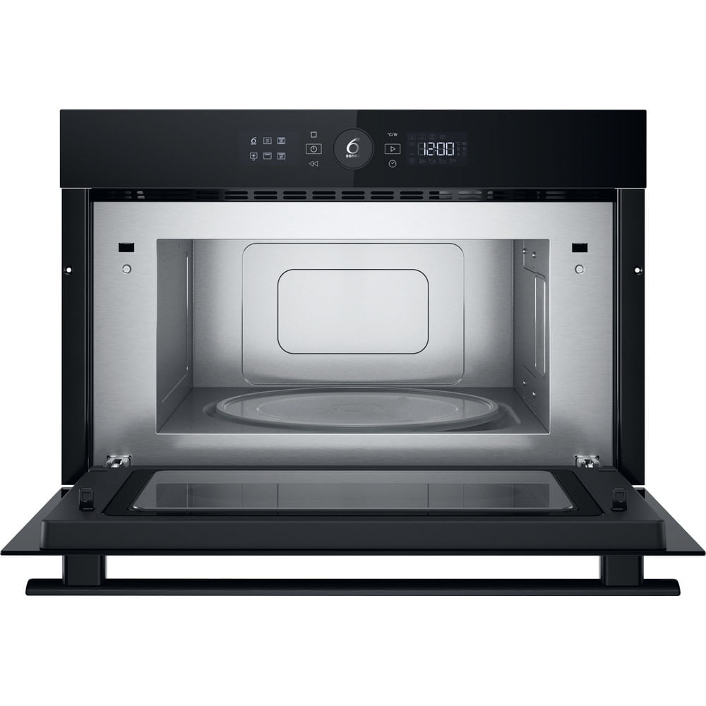 Horno microondas negro con puerta abierta, plato de vidrio en el interior sobre fondo blanco.