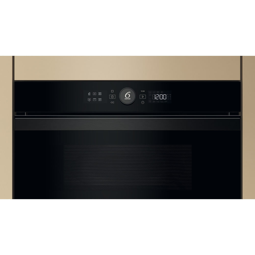 Un horno negro empotrado con una pantalla digital, con una pared de color claro a su alrededor.