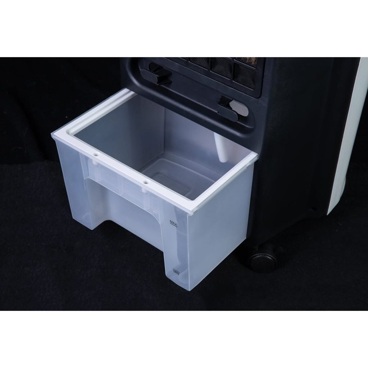 Serbatoio dell'acqua aperto di un condizionatore d'aria bianco e nero, con un cassetto traslucido bianco, su nero.