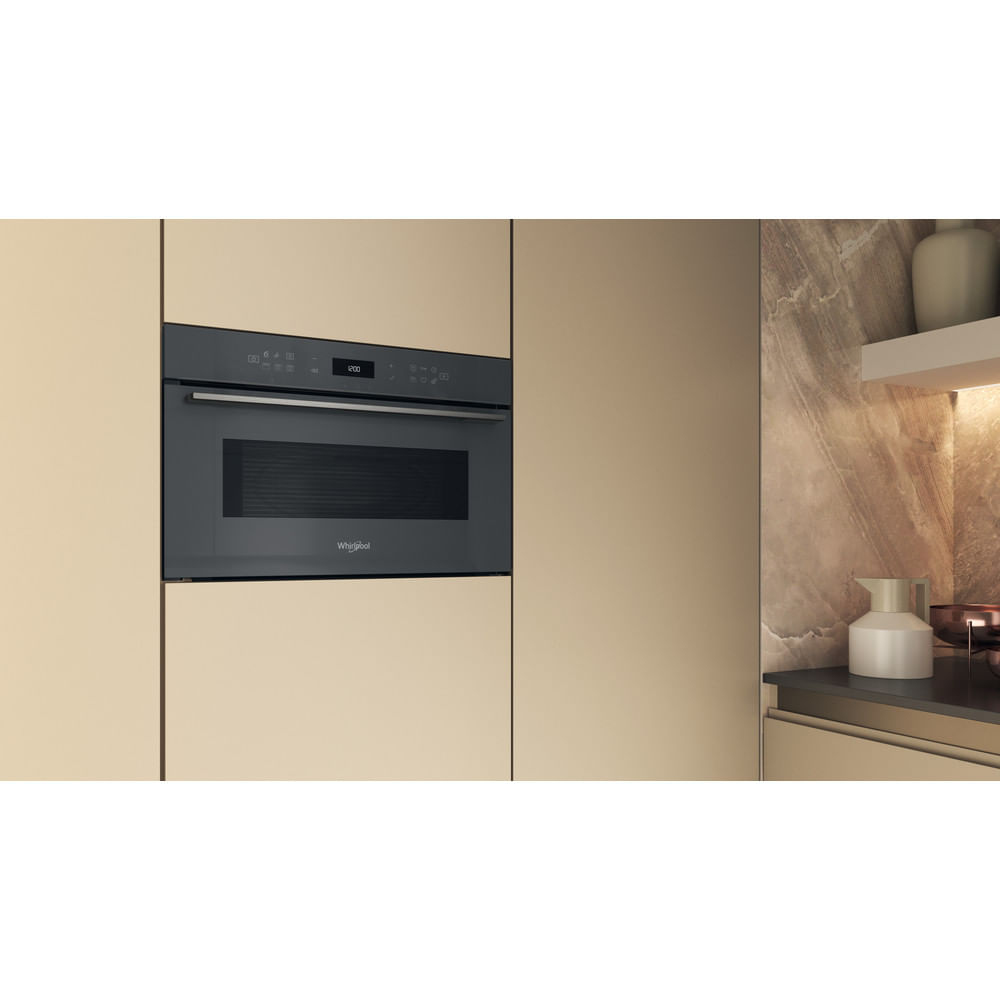 Black microwave built into a cabinet, with a digital display.