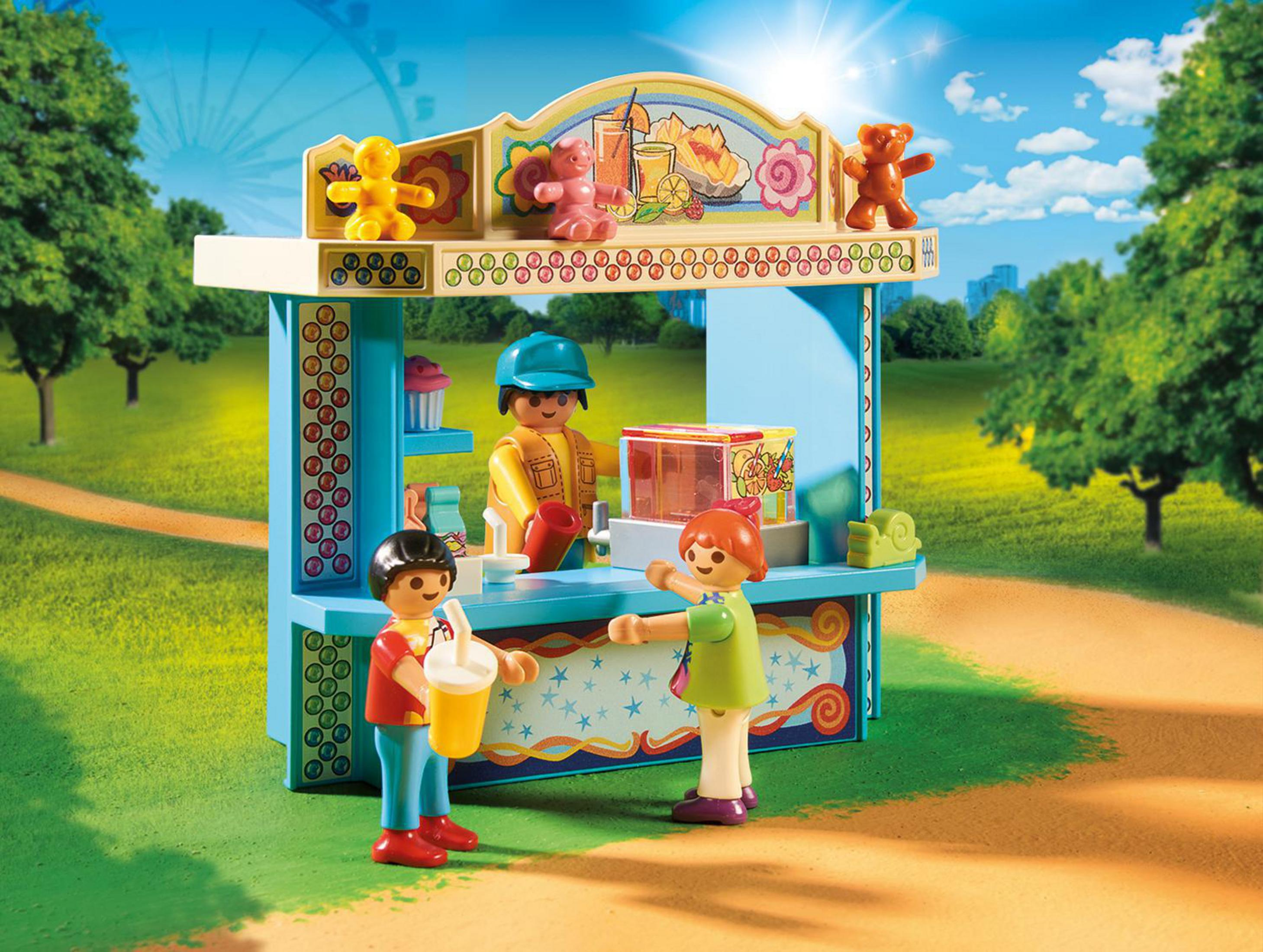 Una escena de juguetes Playmobil en un parque con un puesto de comida, dos niños y un adulto. Hierba verde.