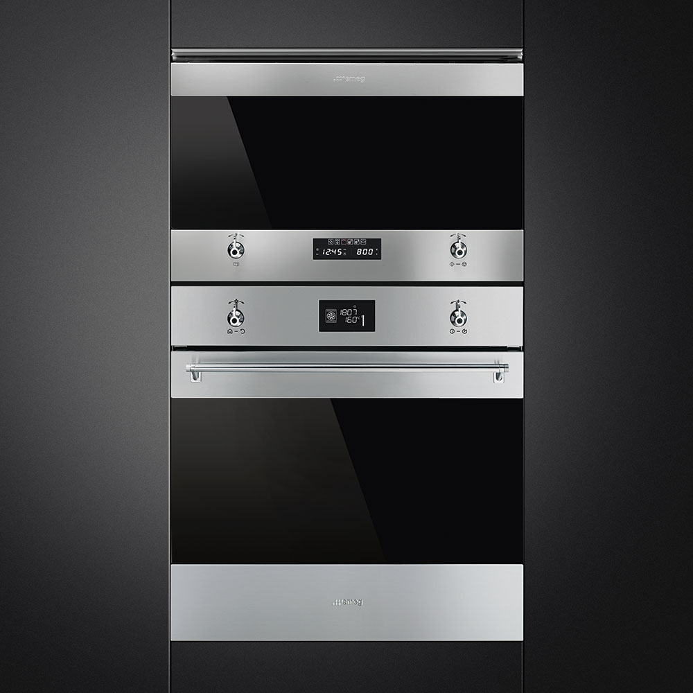 Forni Smeg; due forni con porte in vetro nero e pannello comandi, su muro nero.