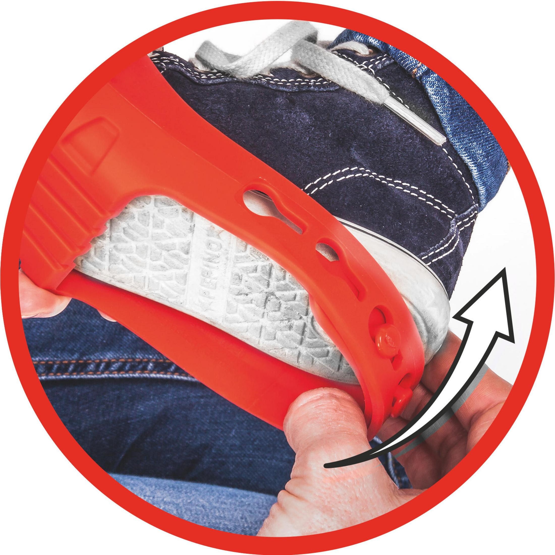 Ręka zakładająca czerwoną osłonę na but na niebieską tenisówkę, w czerwonym okręgu.