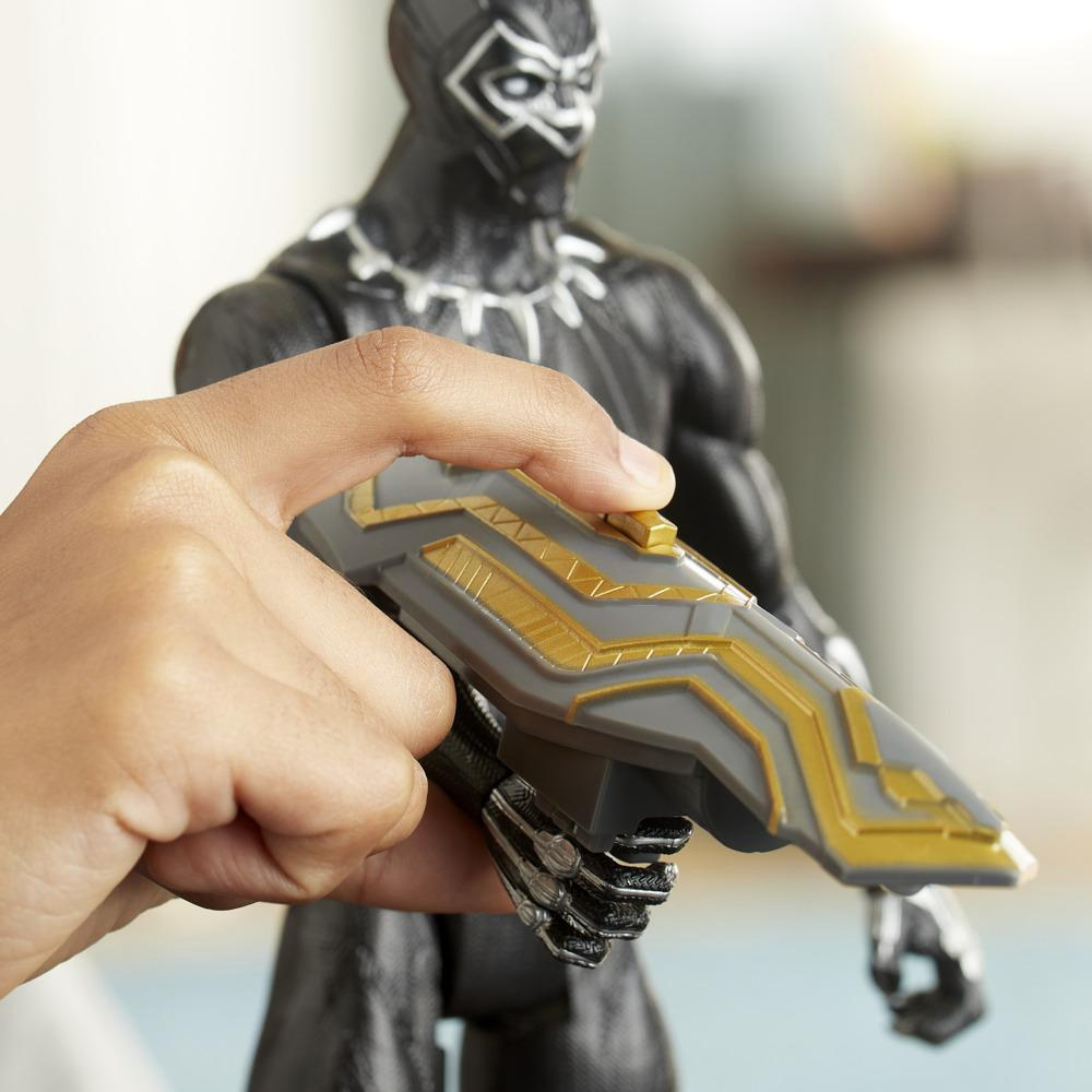 Mano che tiene uno scudo giocattolo di Black Panther. Lo scudo è grigio e dorato.