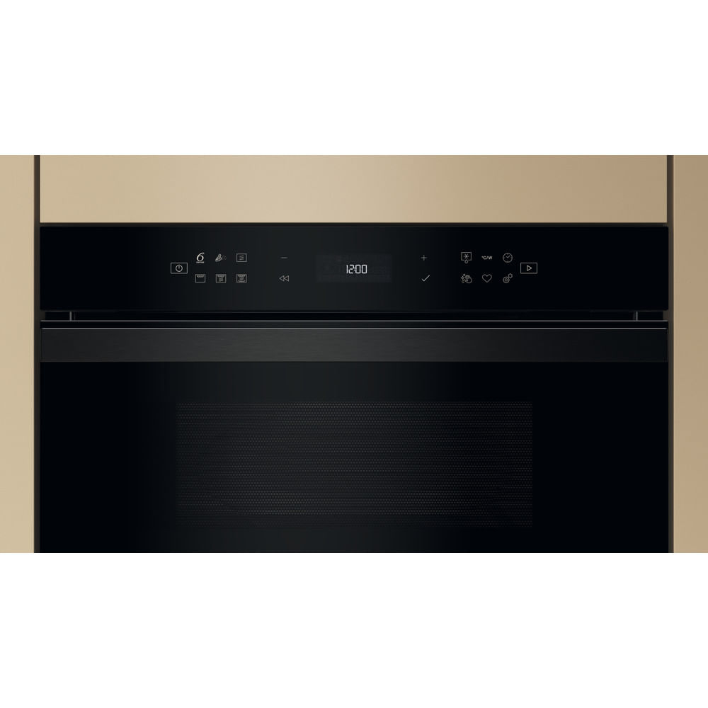 Un panel de control de horno microondas con reloj digital e iconos, gabinete beige.