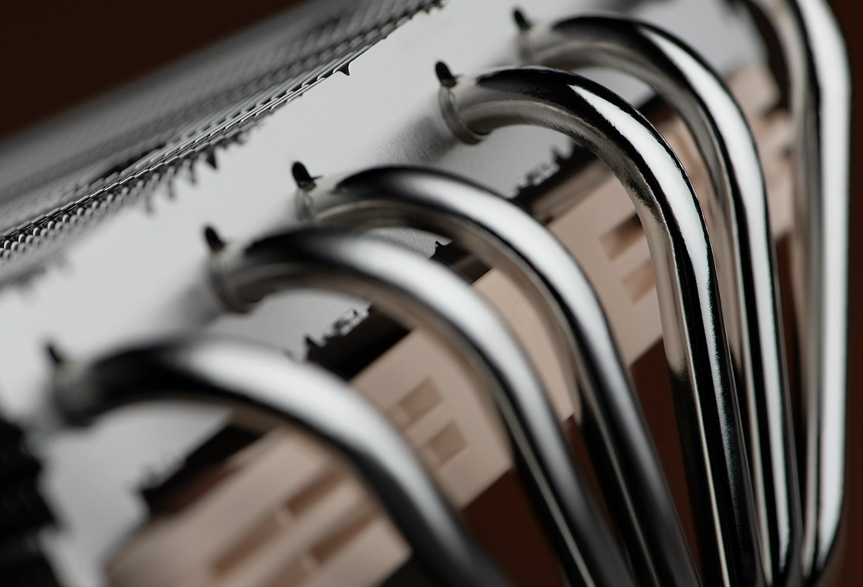Macro shot of silver metal pipes connected to a computer component.