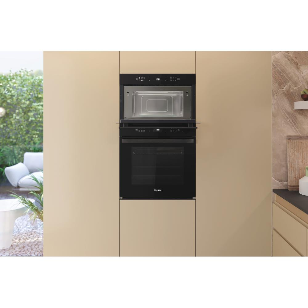 Wbudowana kuchenka mikrofalowa i piekarnik w szafce kuchennej.