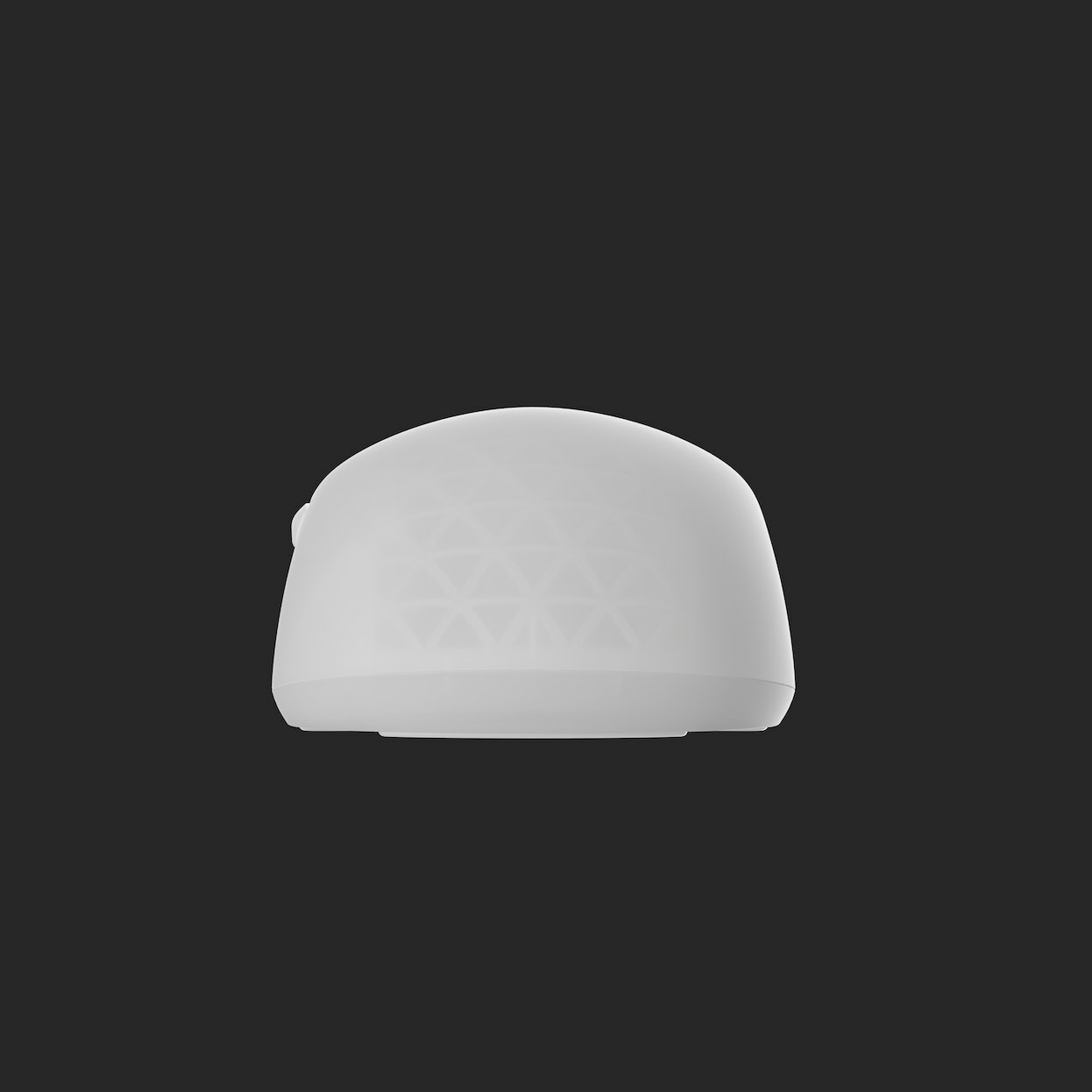 White, rounded-top object with triangular patterns. Sits on a dark surface. The object is a speaker.