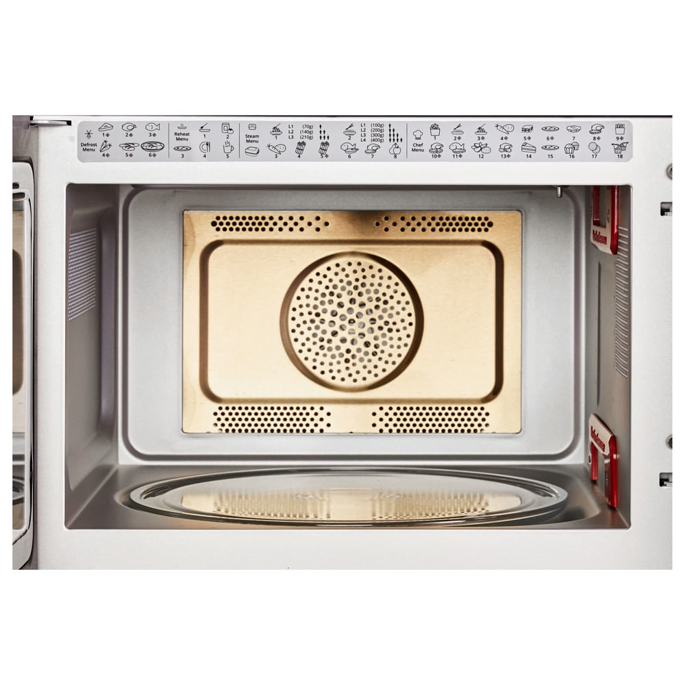 Interior of a microwave, with a golden-colored heating element and glass plate. White frame.