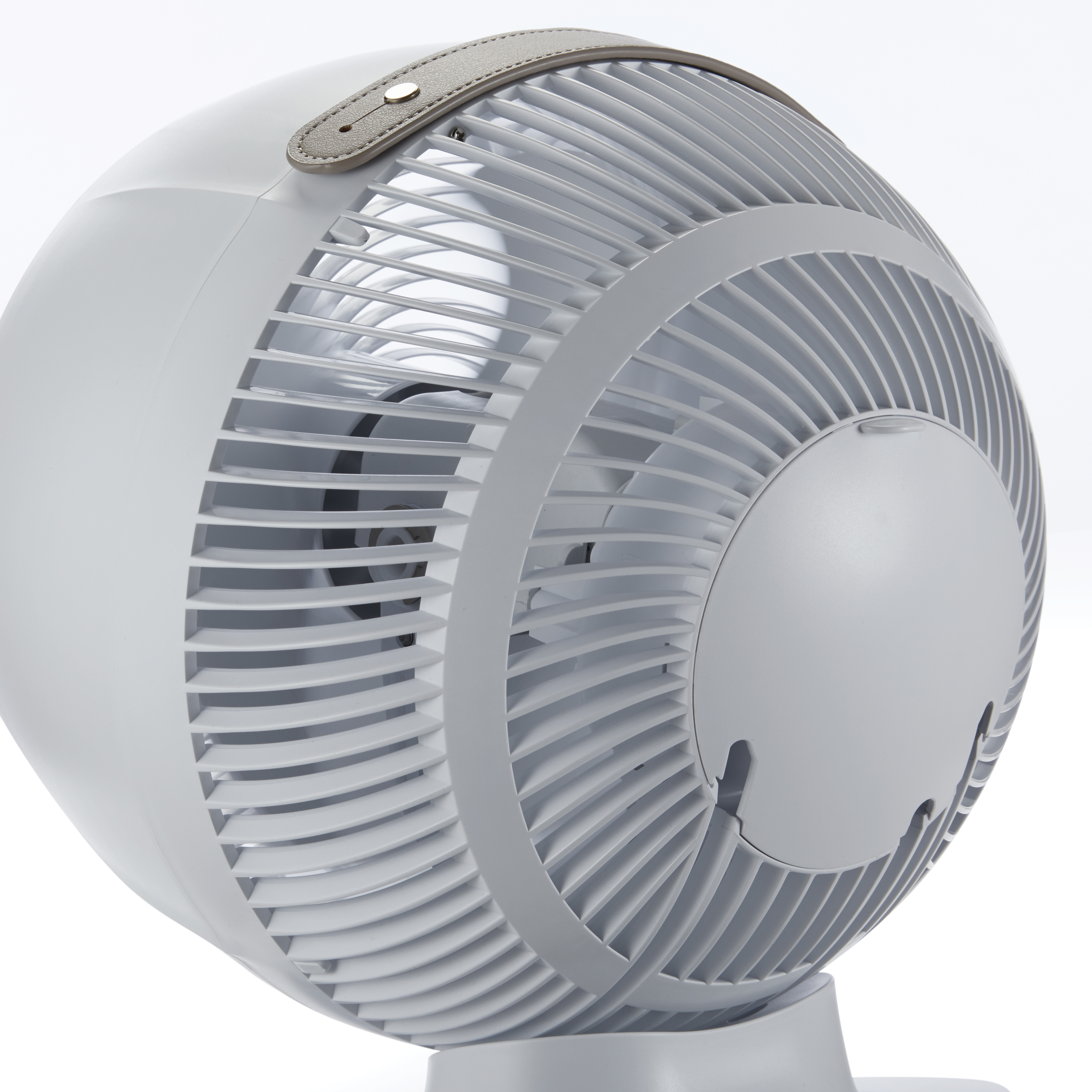 Weißer Ventilator mit Griff. Der Ventilator hat ein kreisförmiges Design und einen grauen Griff.