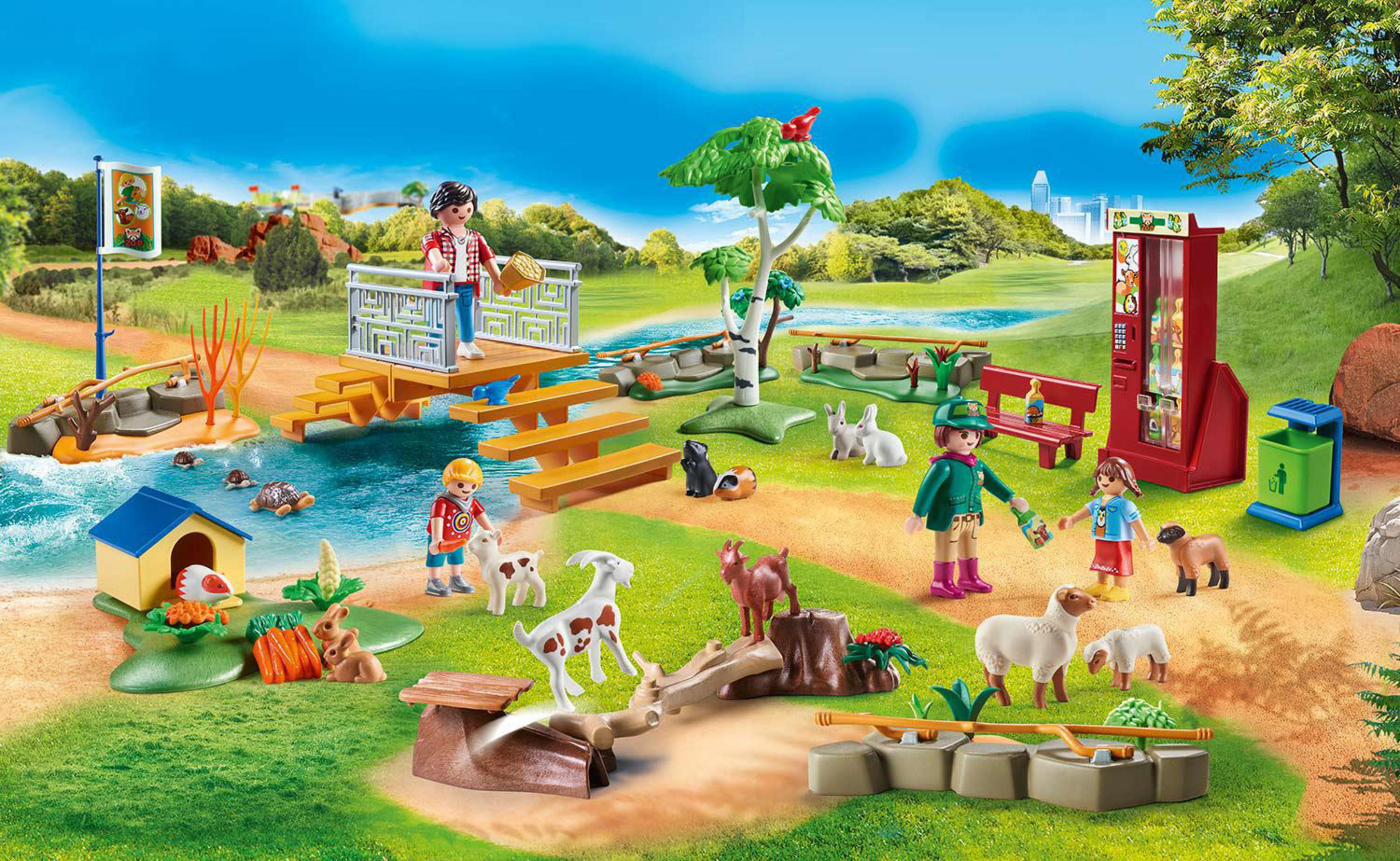 Ein Playmobil Zoo-Set mit vielen Figuren und Tieren auf grünem Gras und einem Teich.