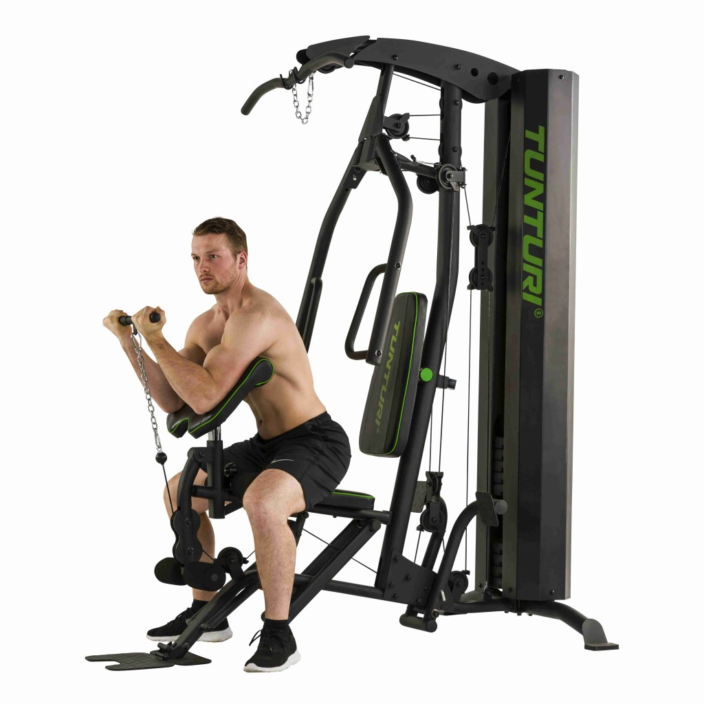 Un uomo sta usando una macchina da palestra Tunturi per fare curl con i bicipiti.