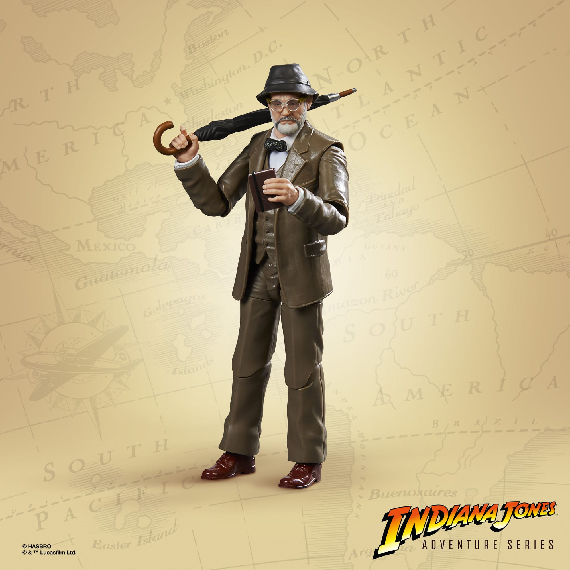Indiana Jones Figur in braunem Anzug, Brille, Hut. Er hält einen Regenschirm und ein Buch, steht auf einer Karte.