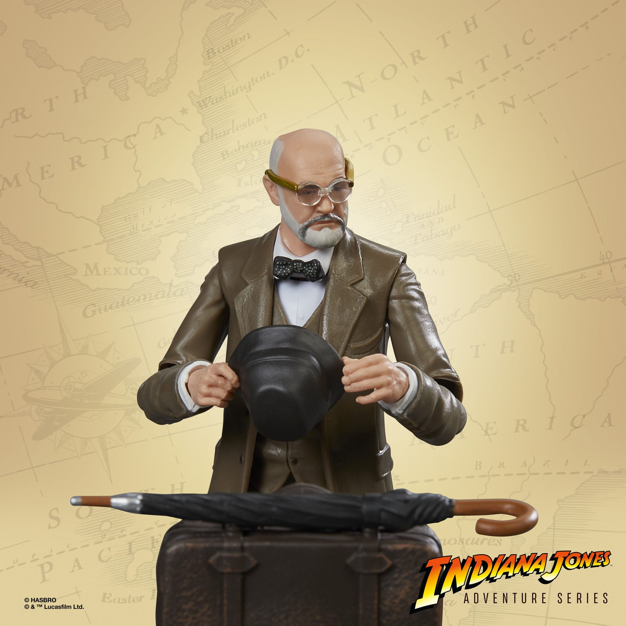 Indiana Jones Figur mit Kartenhintergrund, hält einen Hut und blickt auf einen Regenschirm auf einem Koffer.
