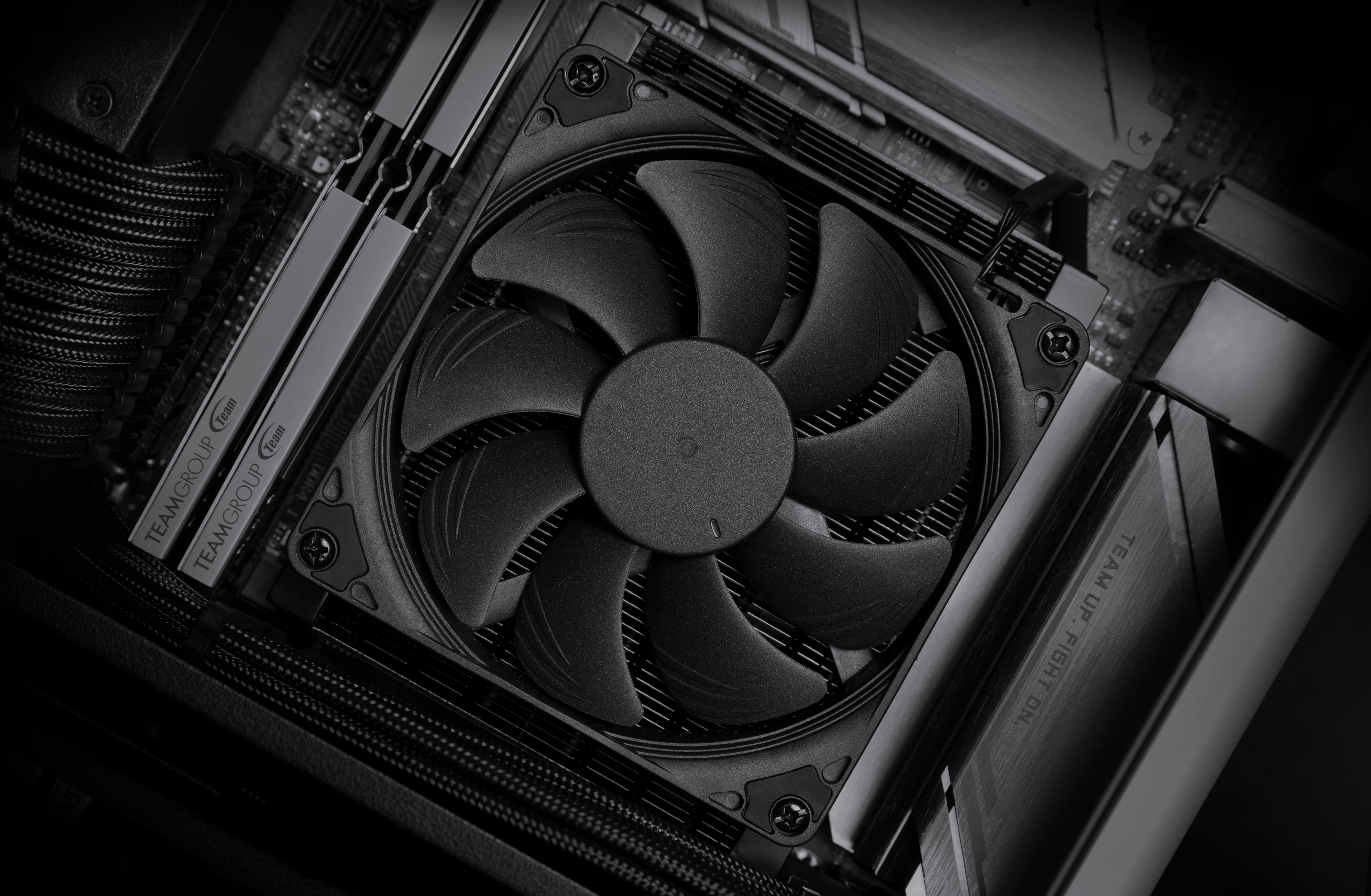 Ventola del dissipatore CPU nera all'interno di un case del computer. Tema scuro.