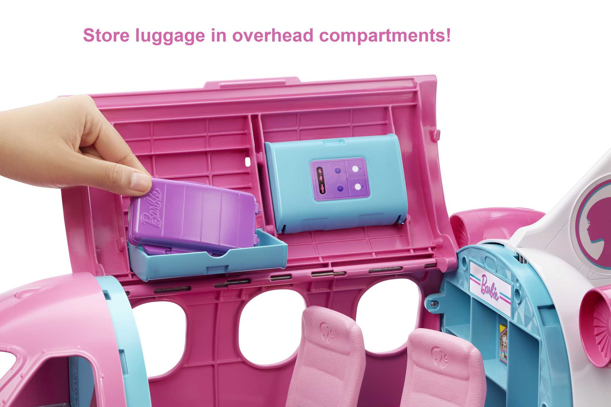 Rosa-weißes Spielzeugflugzeug mit offenem Fach. Eine Hand legt eine lila Box hinein. Blaue Innenausstattung.