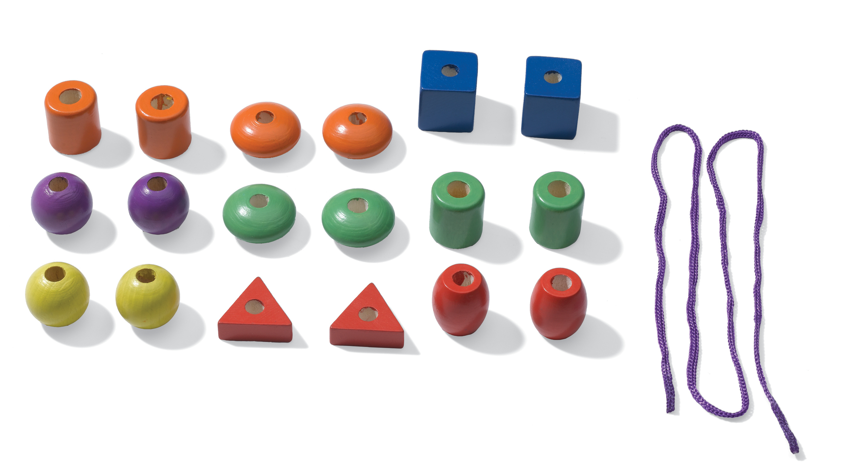 Perline e forme in legno colorate con un cordino viola. Disposte su una superficie bianca.