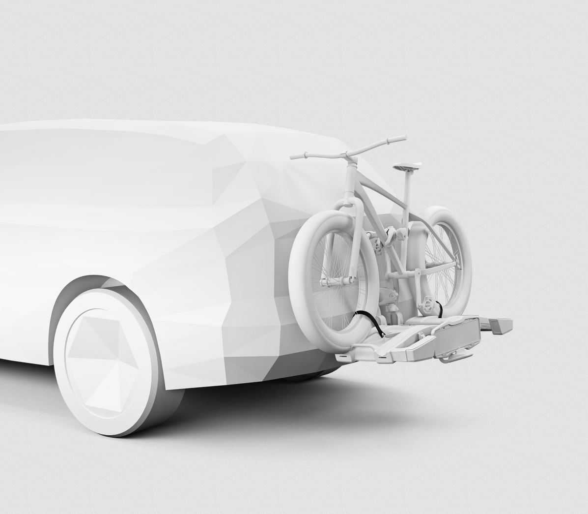 Biały samochód z bagażnikiem rowerowym z tyłu. Rower zamontowany na bagażniku.