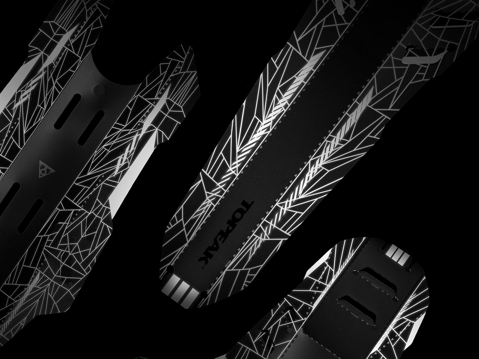 Czarne błotniki rowerowe z białymi geometrycznymi wzorami. Widoczna nazwa marki Topeak.