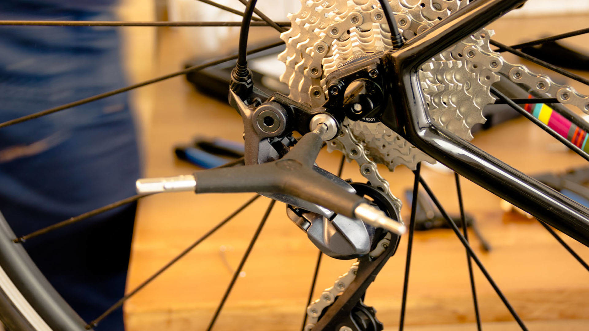 Zbliżenie koła roweru i komponentów. Widoczna przerzutka, łańcuch i opona.