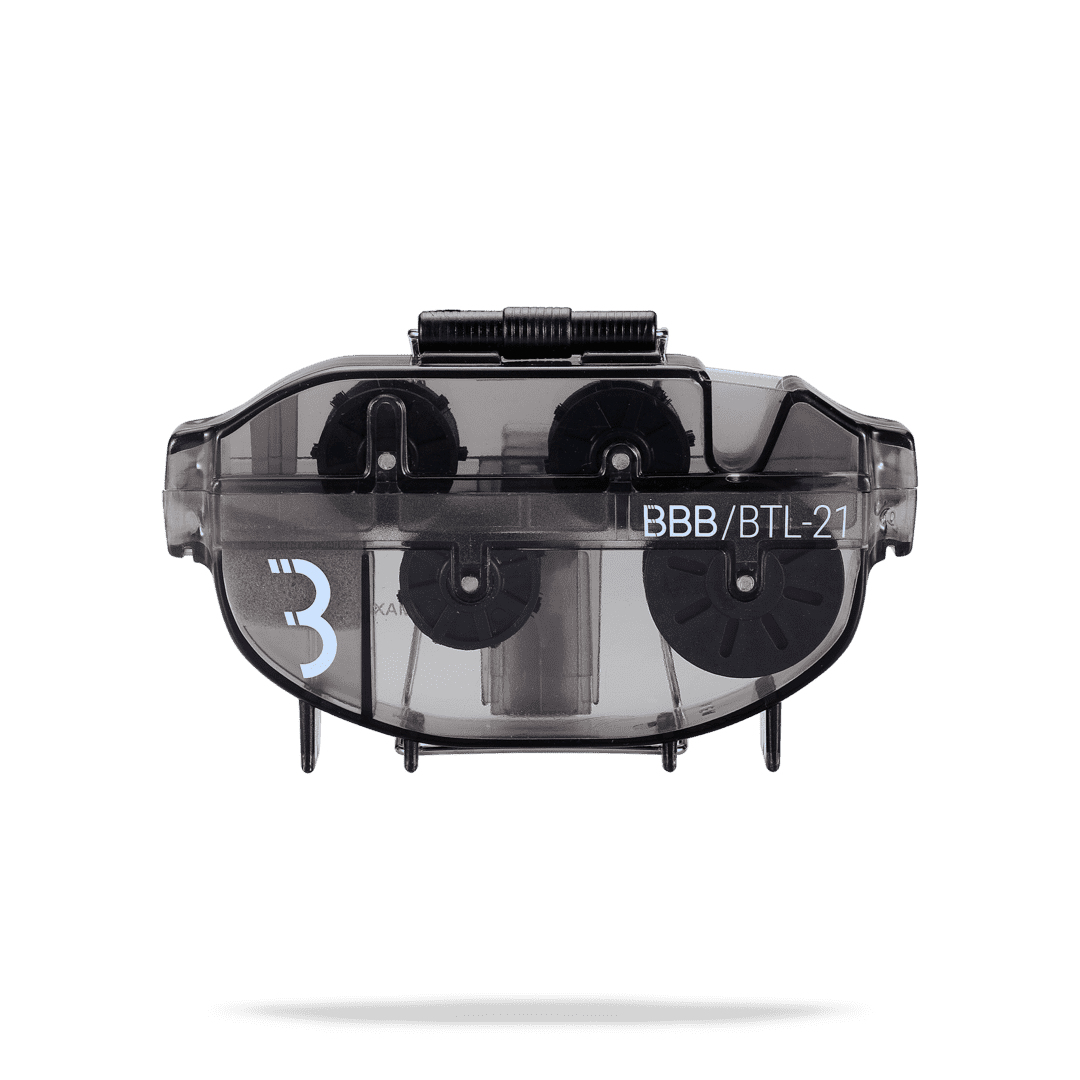 Czarny czyścik do łańcucha rowerowego z trzema obracającymi się szczotkami. Przezroczysty korpus. Białe tło.