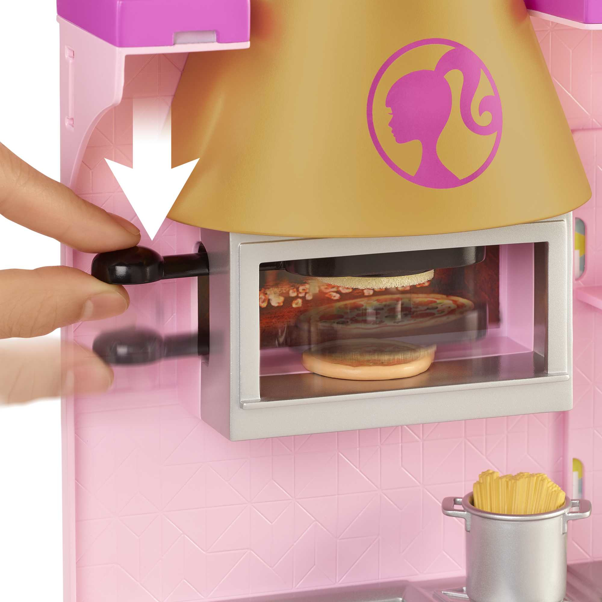 Una mano gira una manopola nera per azionare un forno da cucina Barbie con la pizza all'interno.