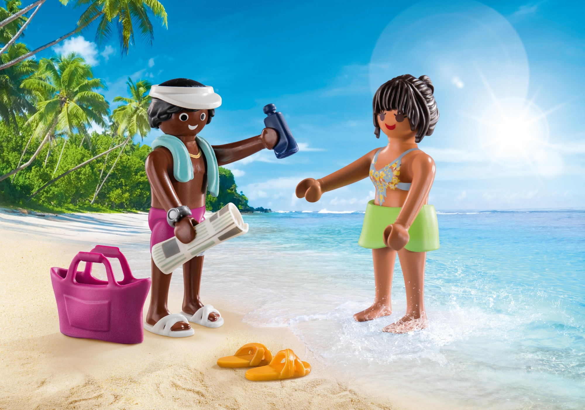 Dwie figurki Playmobil na plaży. Jedna nakłada krem z filtrem na drugą. Tropikalne tło z palmami.