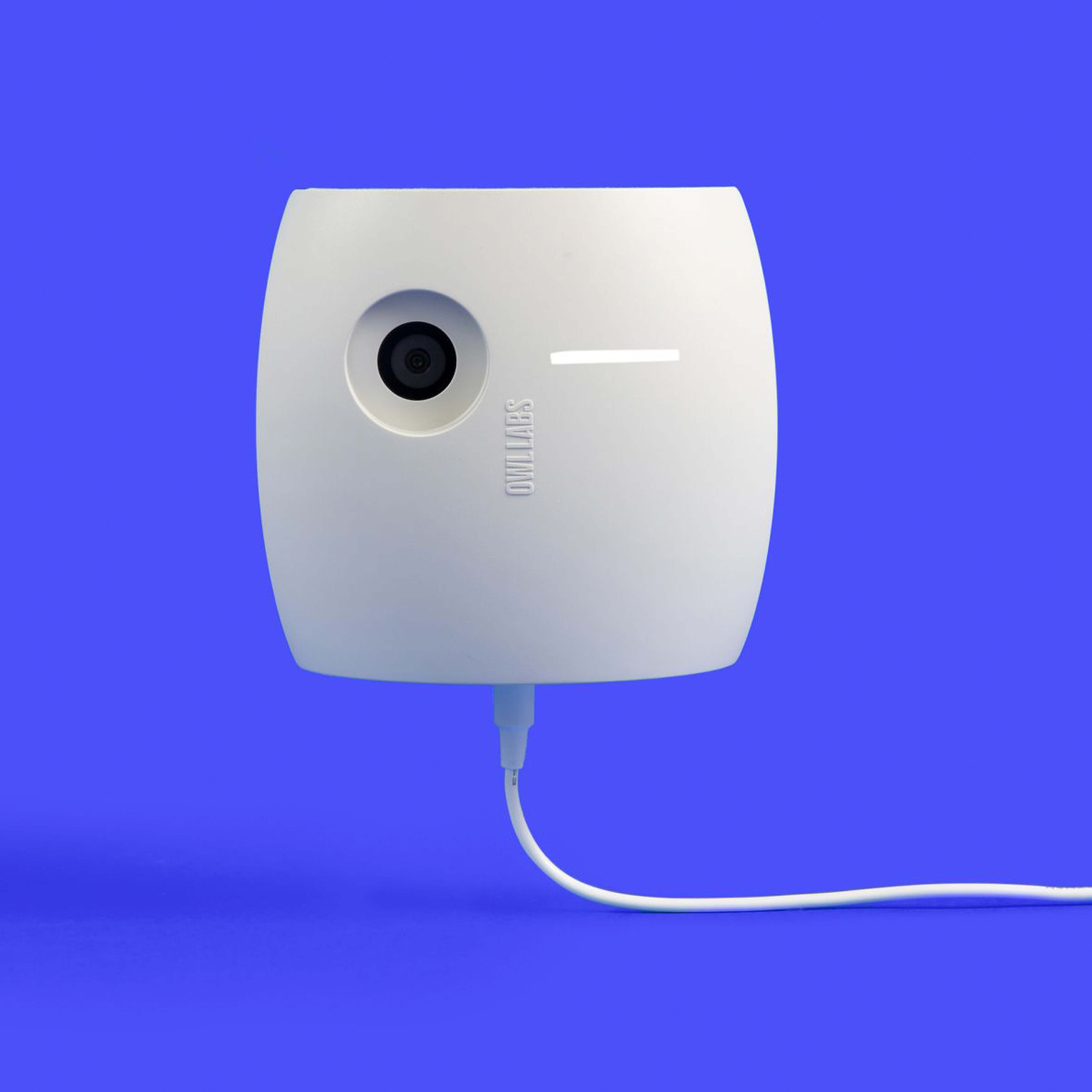 Weißes Kameragerät mit Objektiv und weißem Kabel auf blauem Hintergrund.