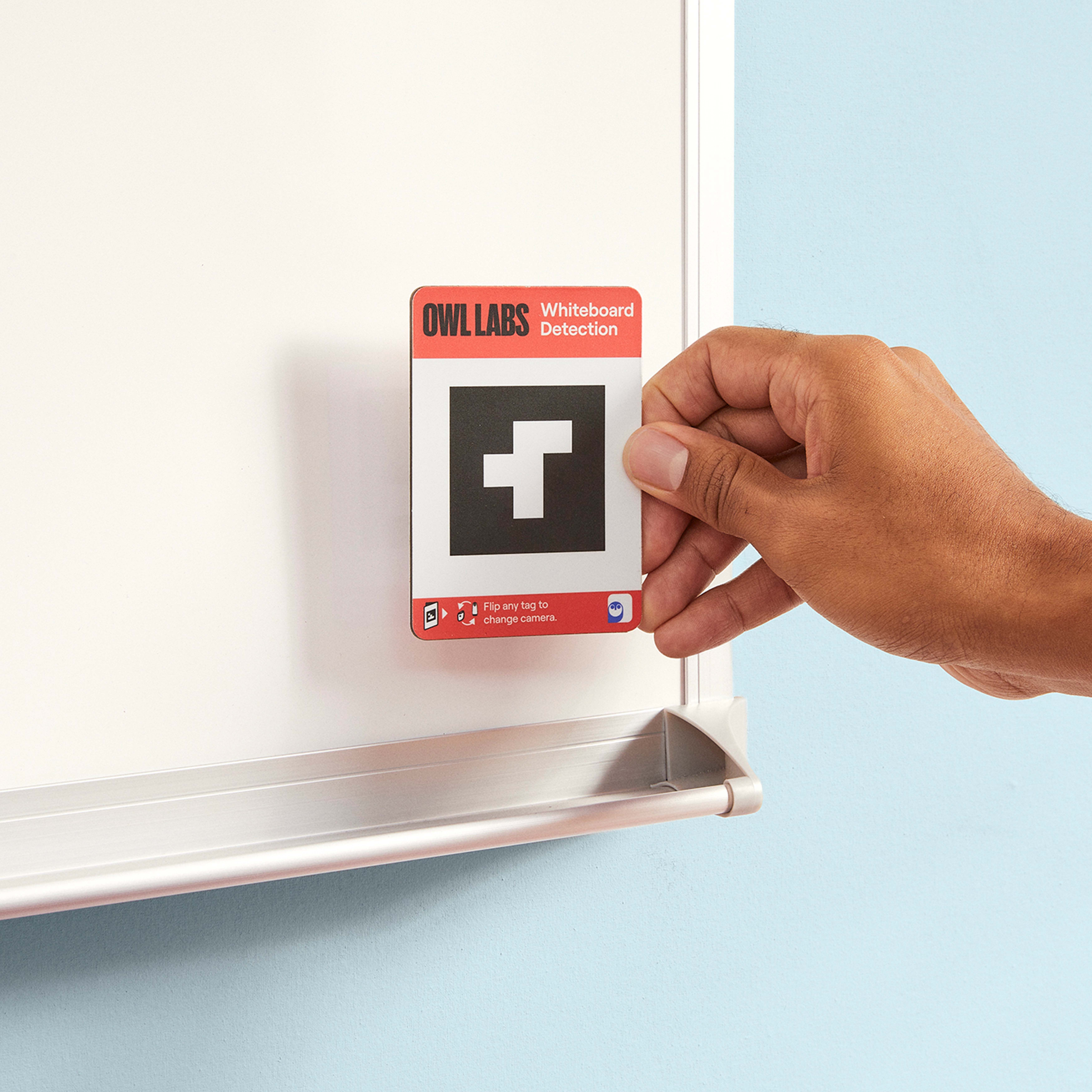 Hand hält eine Whiteboard-Erkennungskarte vor einem Whiteboard, mit einem schwarz-weißen Quadrat.