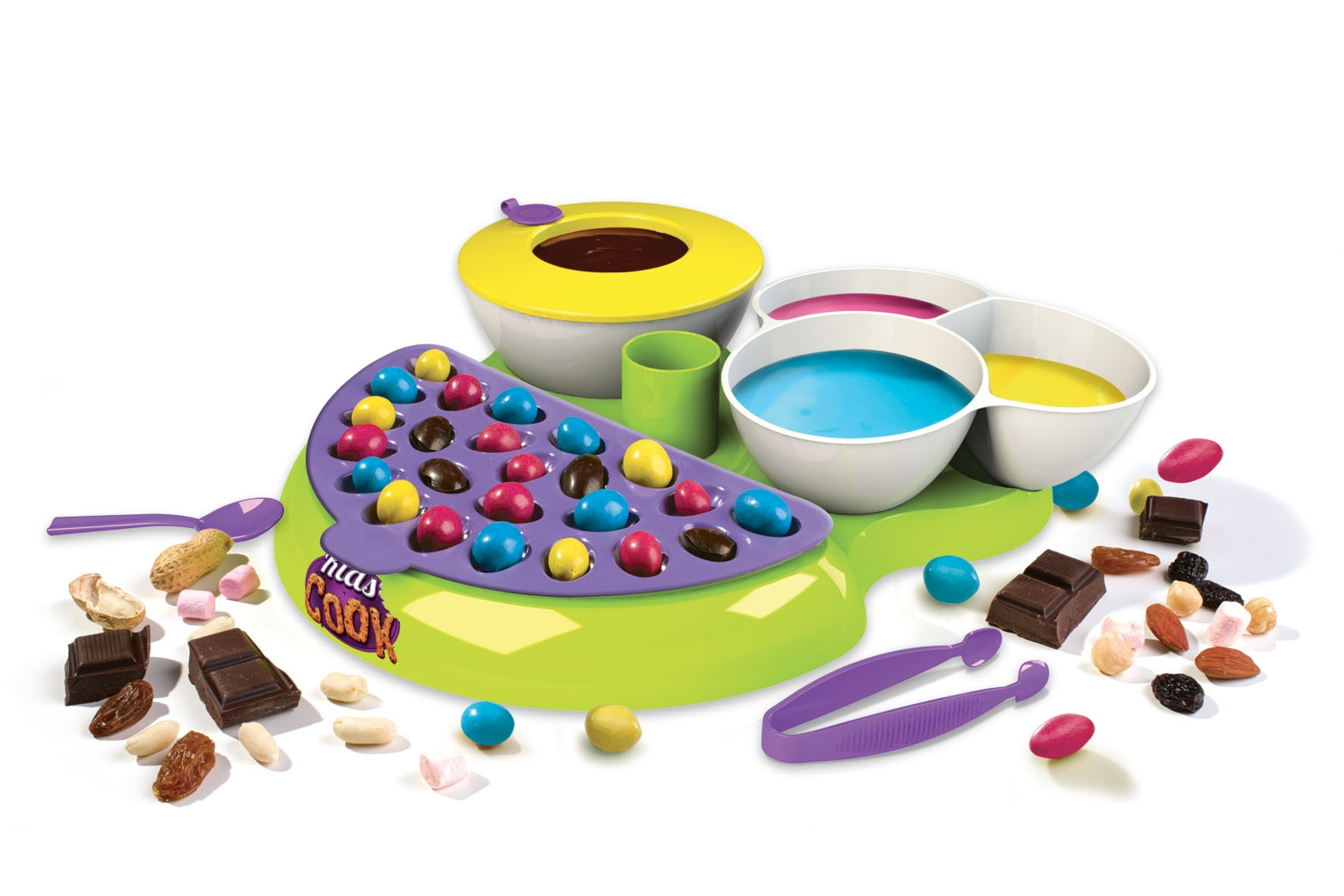 Zestaw do robienia słodyczy z miskami, czekoladami, cukierkami, orzechami i narzędziami na zielonej powierzchni.