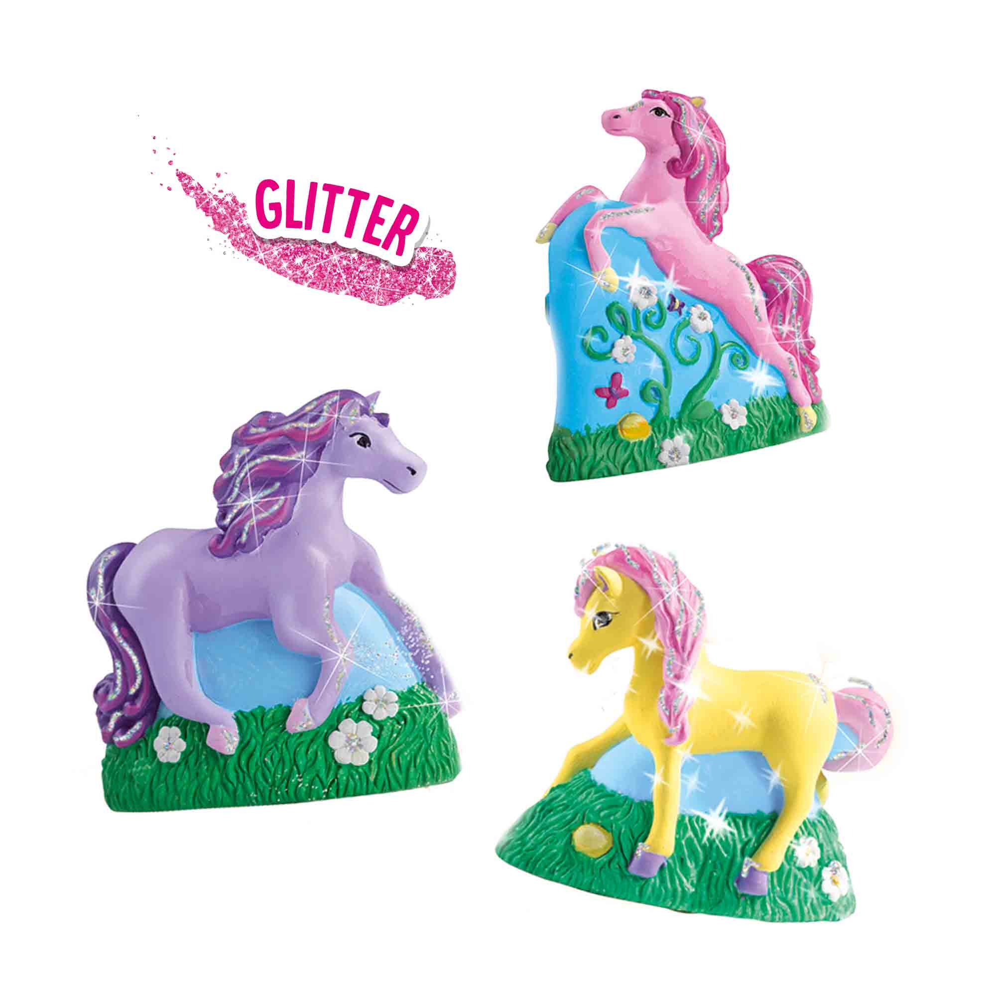 Trzy błyszczące figurki jednorożców w różnych kolorach, na zielonych i niebieskich podstawach.
