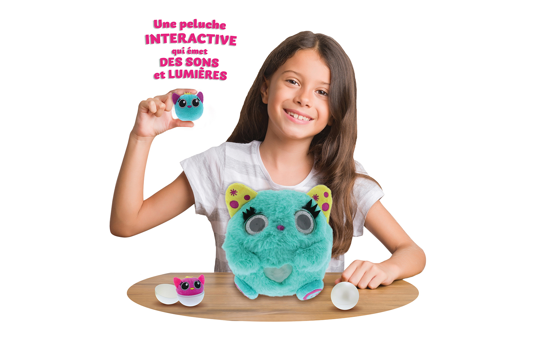 Dziewczyna trzyma pluszową zabawkę i dwa jajka. Tekst mówi 'interaktywna pluszowa zabawka, która emituje dźwięki i światło'.