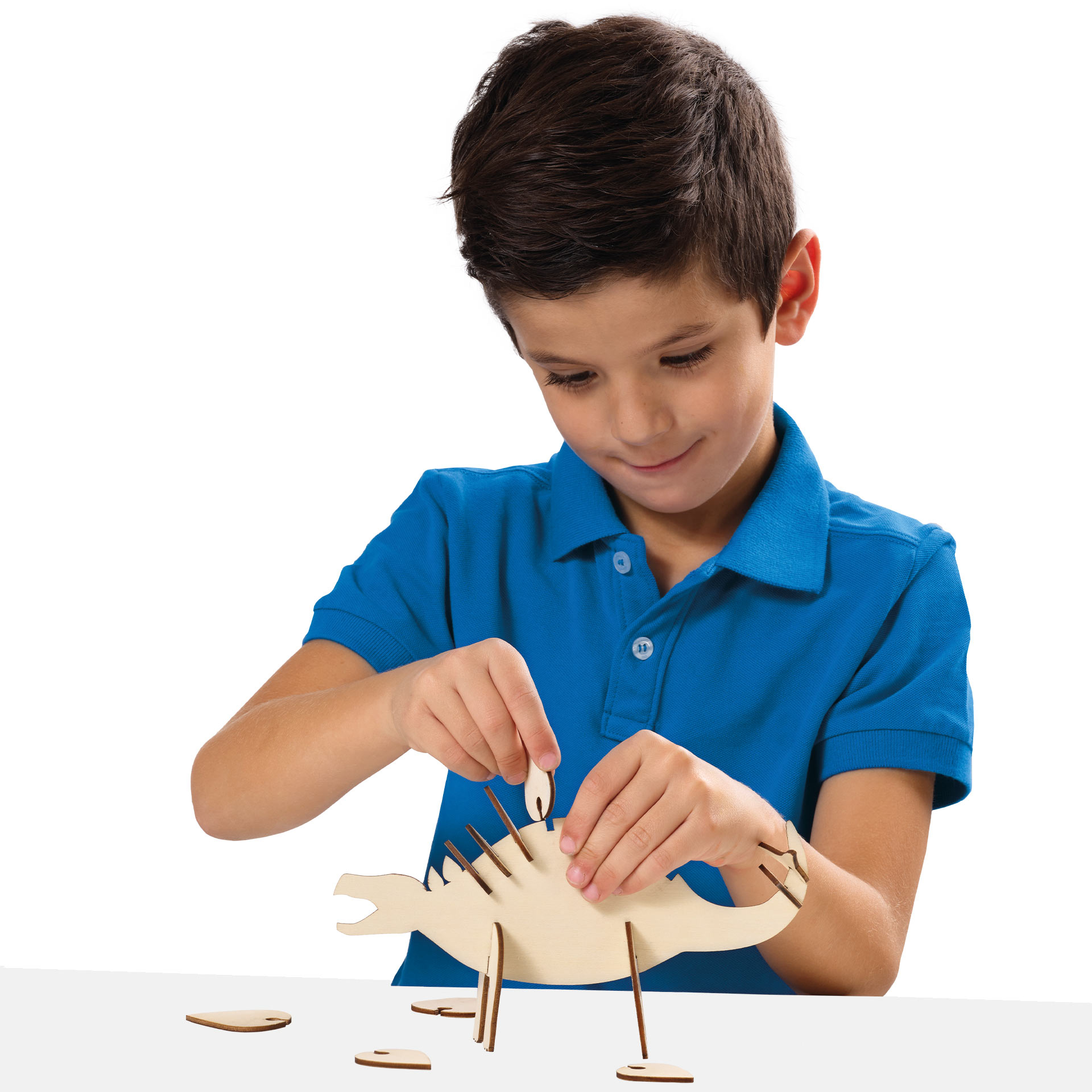 Chłopiec składający drewniany model dinozaura.