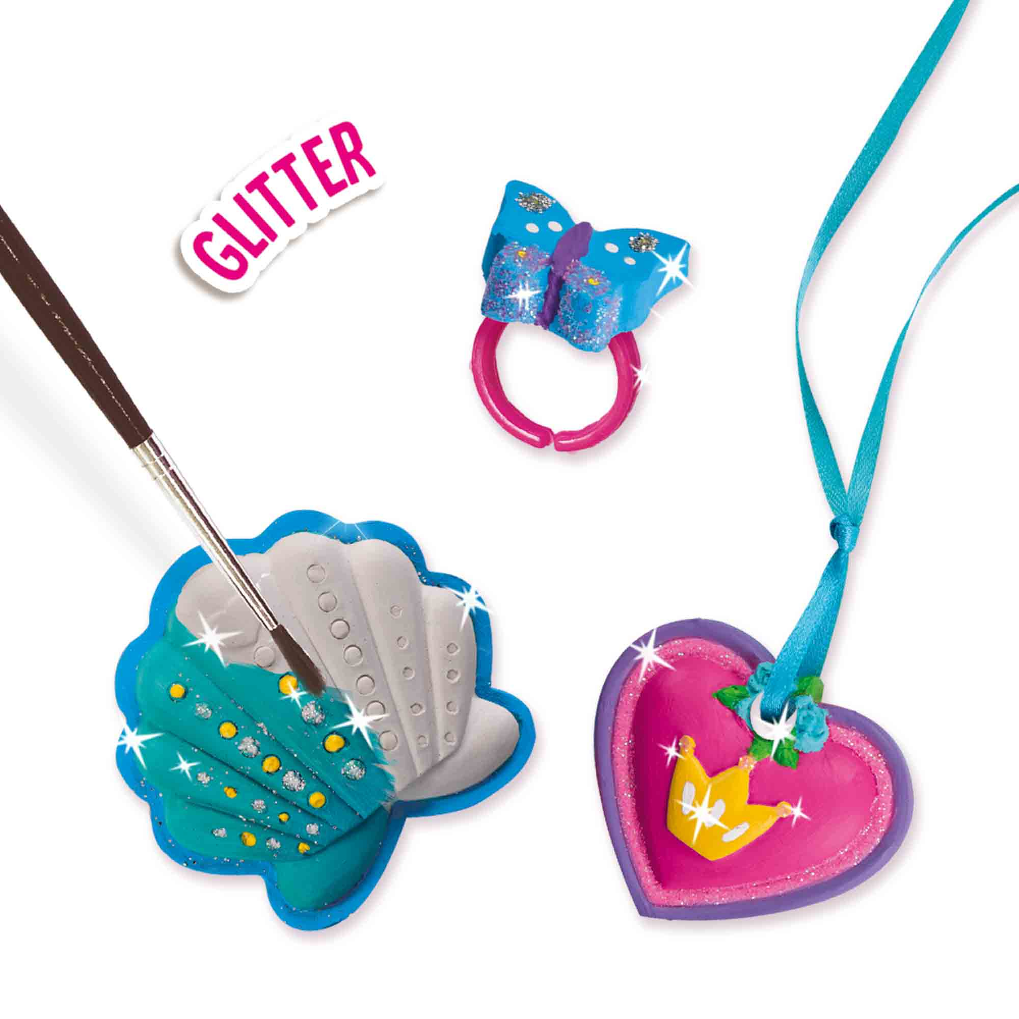 Zbliżenie na materiały do robienia biżuterii: pierścionek, muszla, wisiorek w kształcie serca i pędzel.