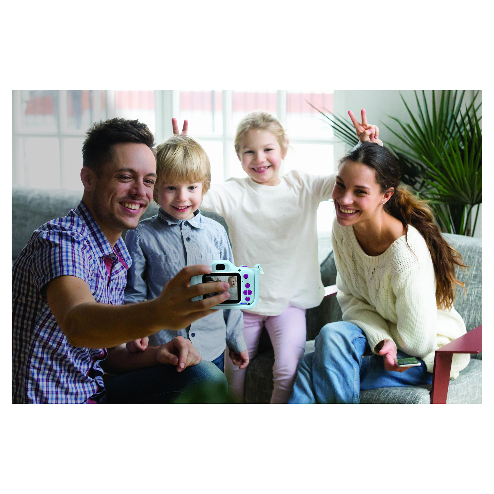 Una famiglia che fa un selfie con una fotocamera blu, sorridendo e facendo il segno della pace.