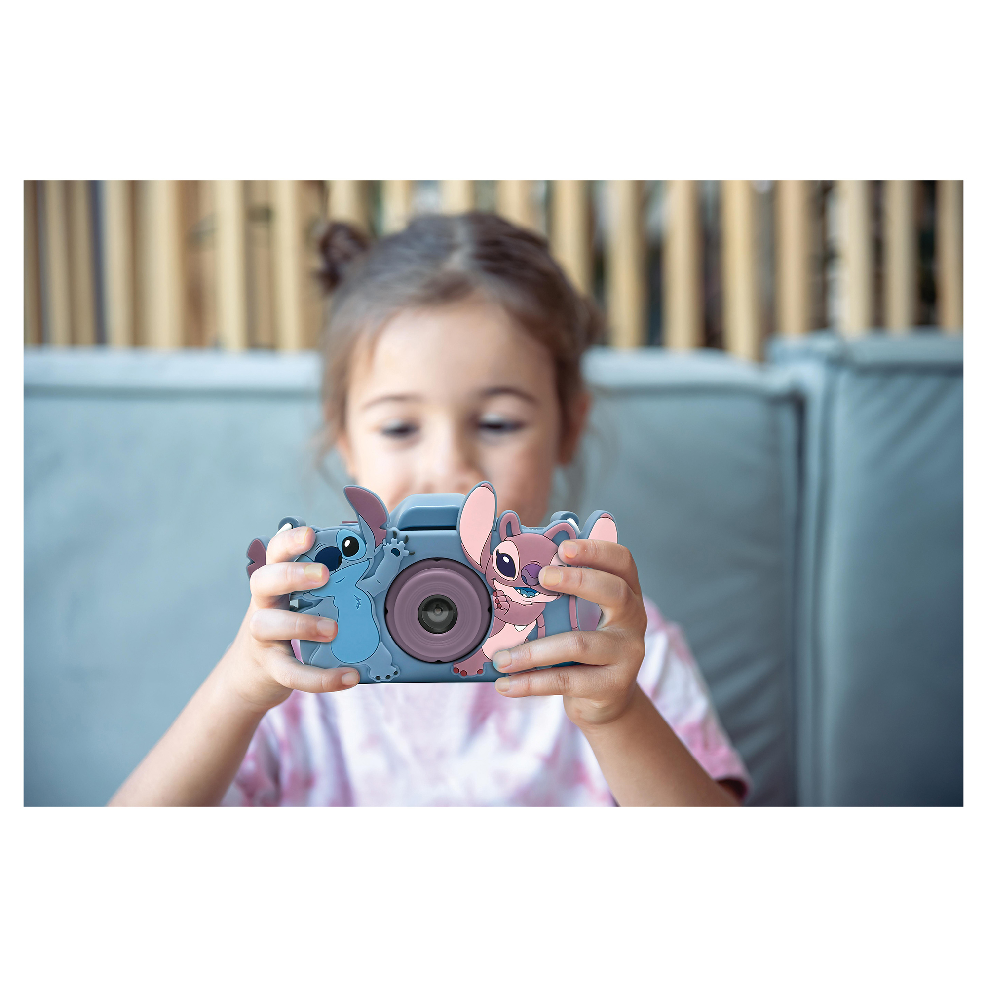 Dziewczyna trzymająca aparat w stylu Stitch i patrząca na niego.