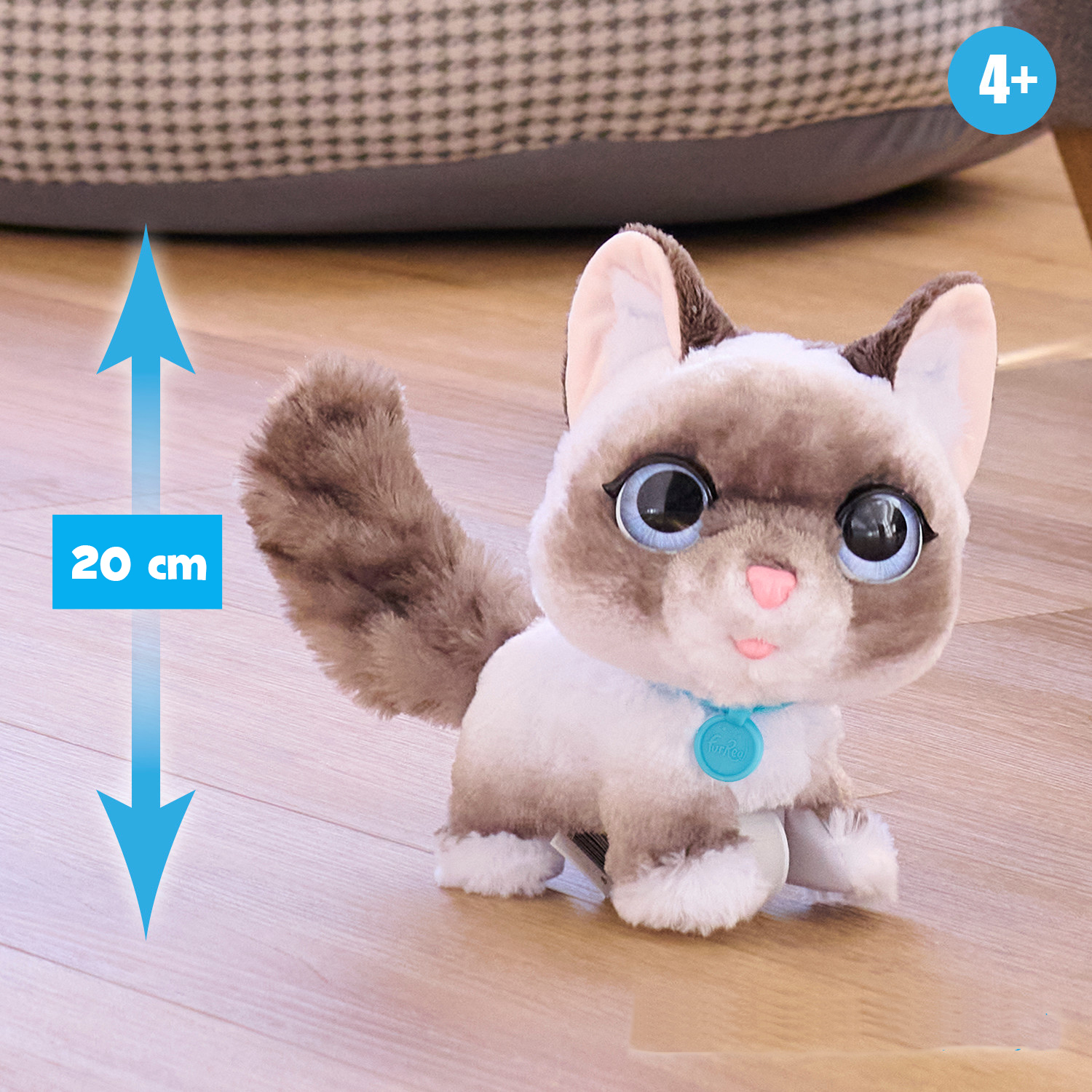 Un gato de juguete con pelaje marrón y blanco. La altura es de 20 cm. Tiene ojos azules.