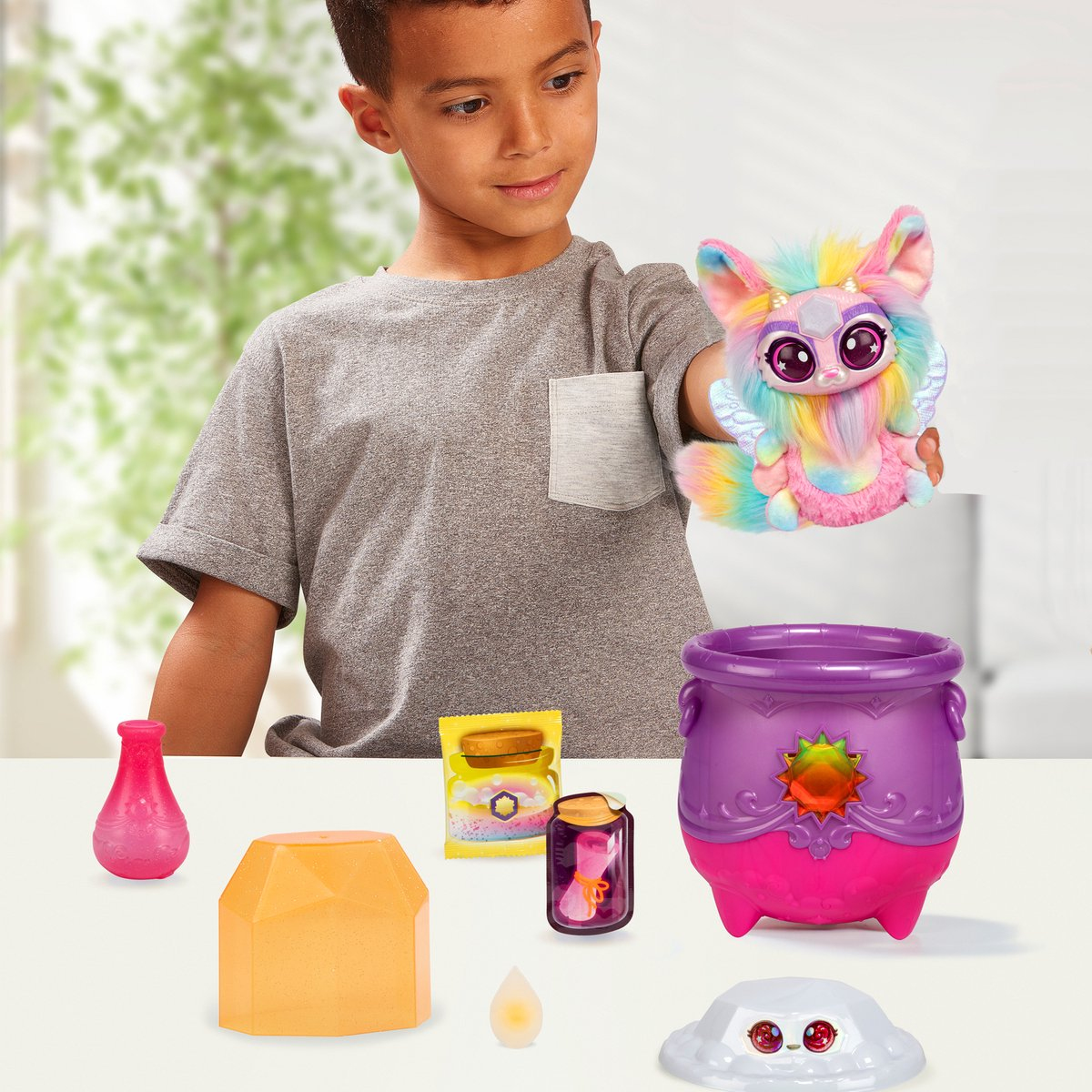 Chłopiec z zabawką i magicznymi przedmiotami na białym stole na tle rozmytego tła.