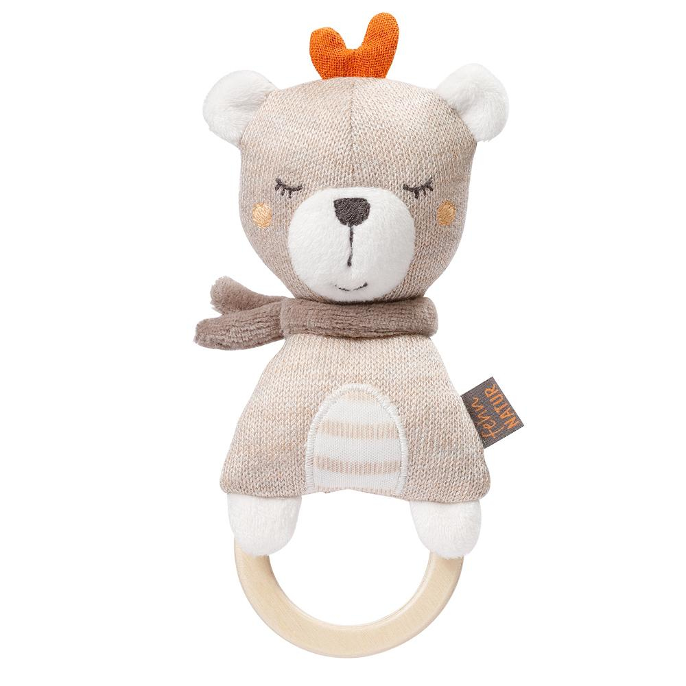 Orsetto di peluche beige con sciarpa marrone e anello di legno. Sfondo bianco.