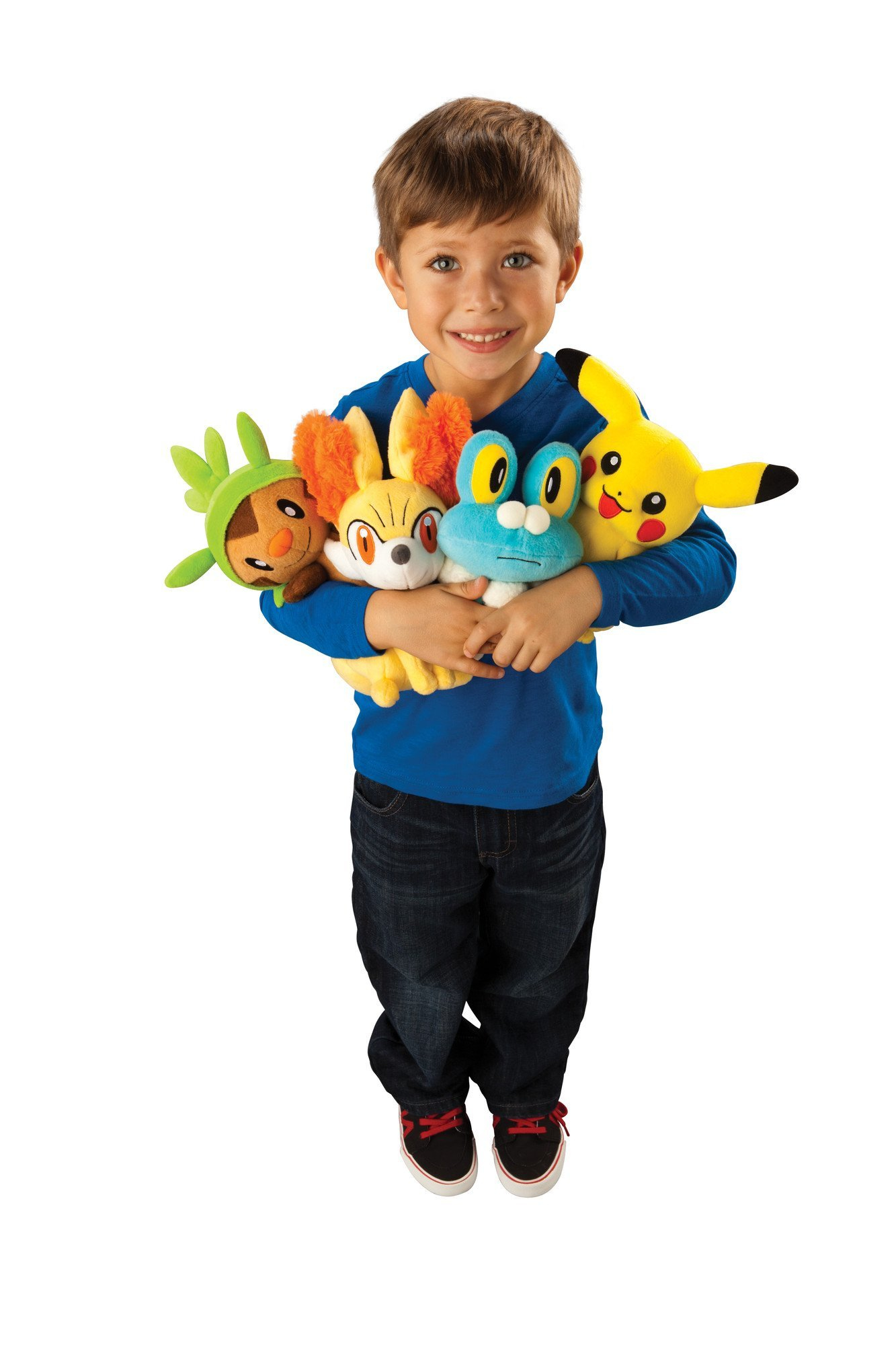Ein Junge, der vier Stoff-Pokémon-Figuren hält. Pikachu, Froakie, Fennekin und Chespin.