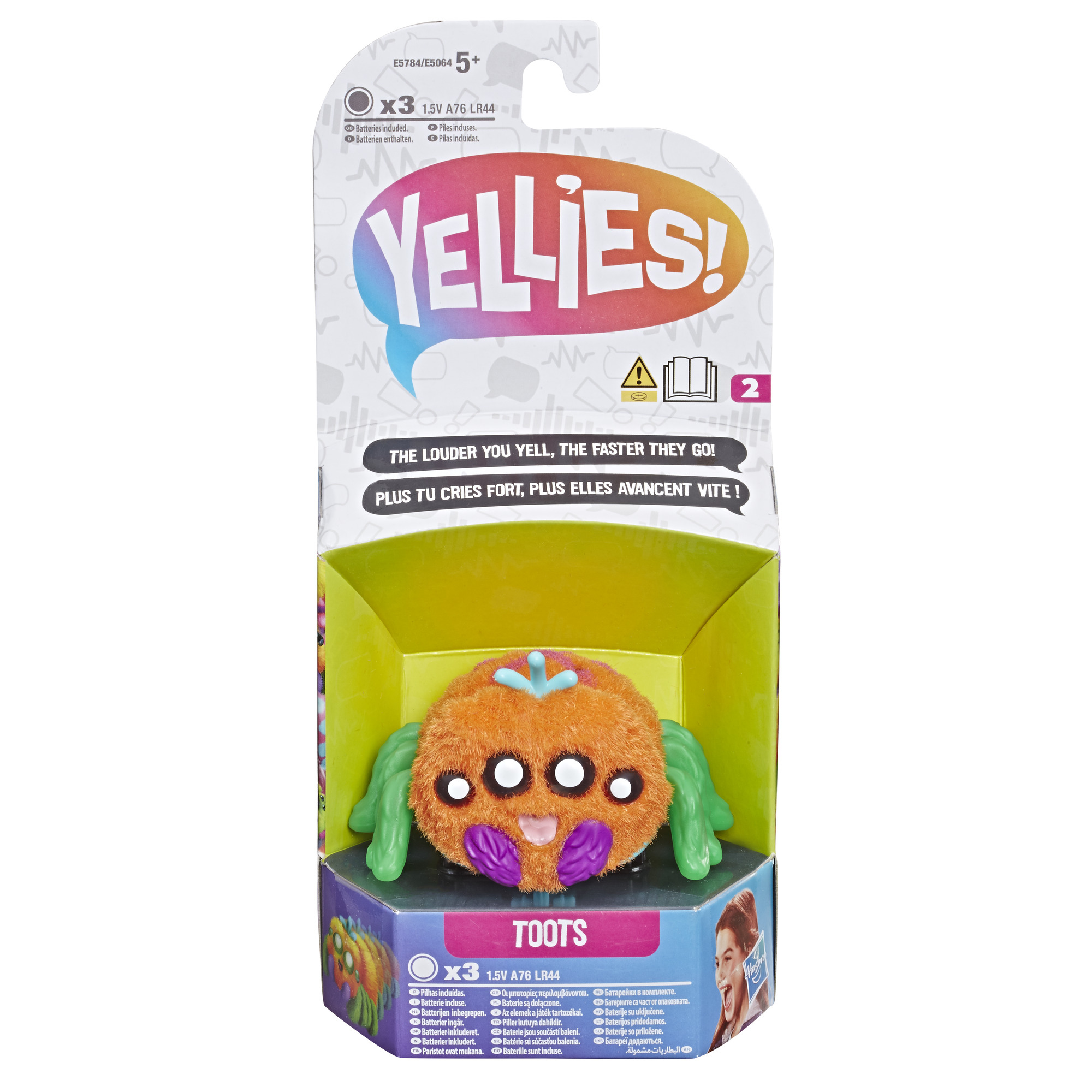 Spielzeug in einer Schachtel, orangefarbenes, pelziges Monster mit grünen Beinen und violetten Akzenten.