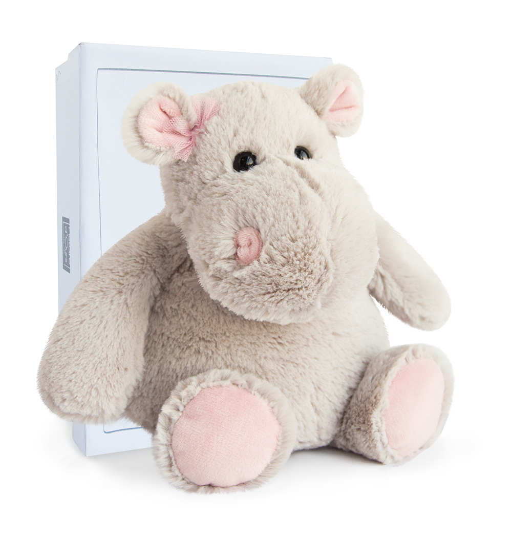 Szara pluszowa zabawka w kształcie hipopotama z różowymi uszami, nosem i kwiatem oraz białe pudełko.