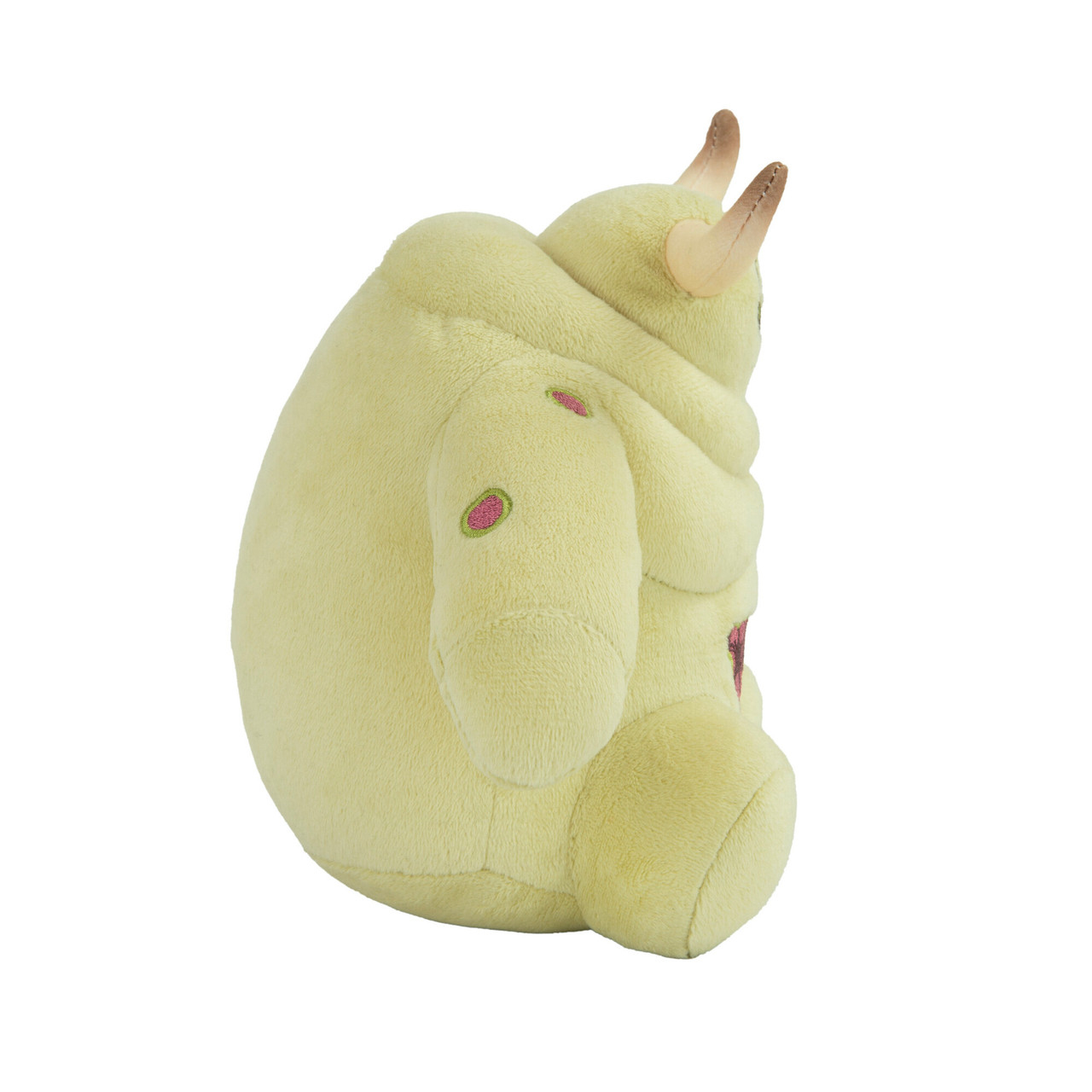 Peluche monstre jaune avec des cornes et des taches roses. Fond blanc.
