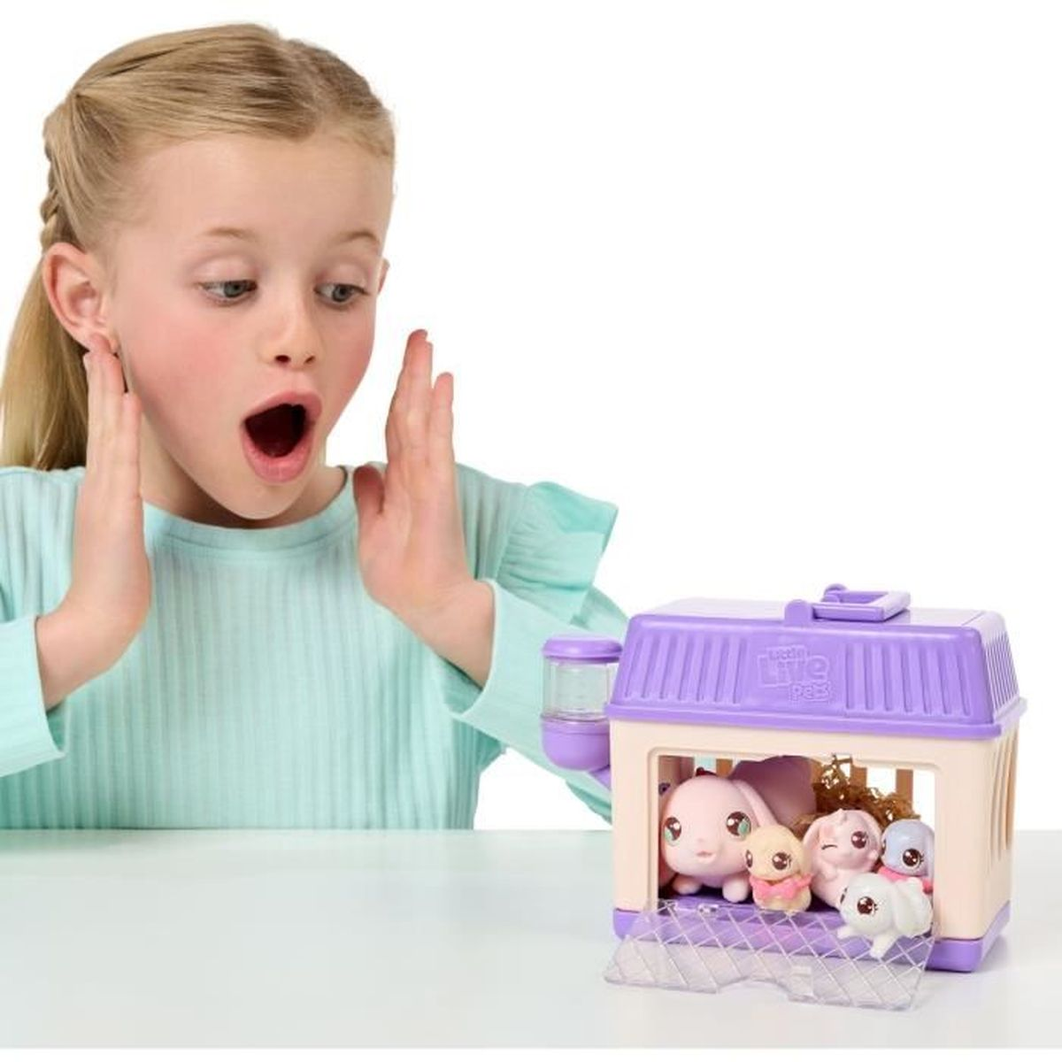 Dziewczynka jest zaskoczona, patrząc na transporter dla zwierząt z zabawkami w środku. Transporter jest fioletowy.