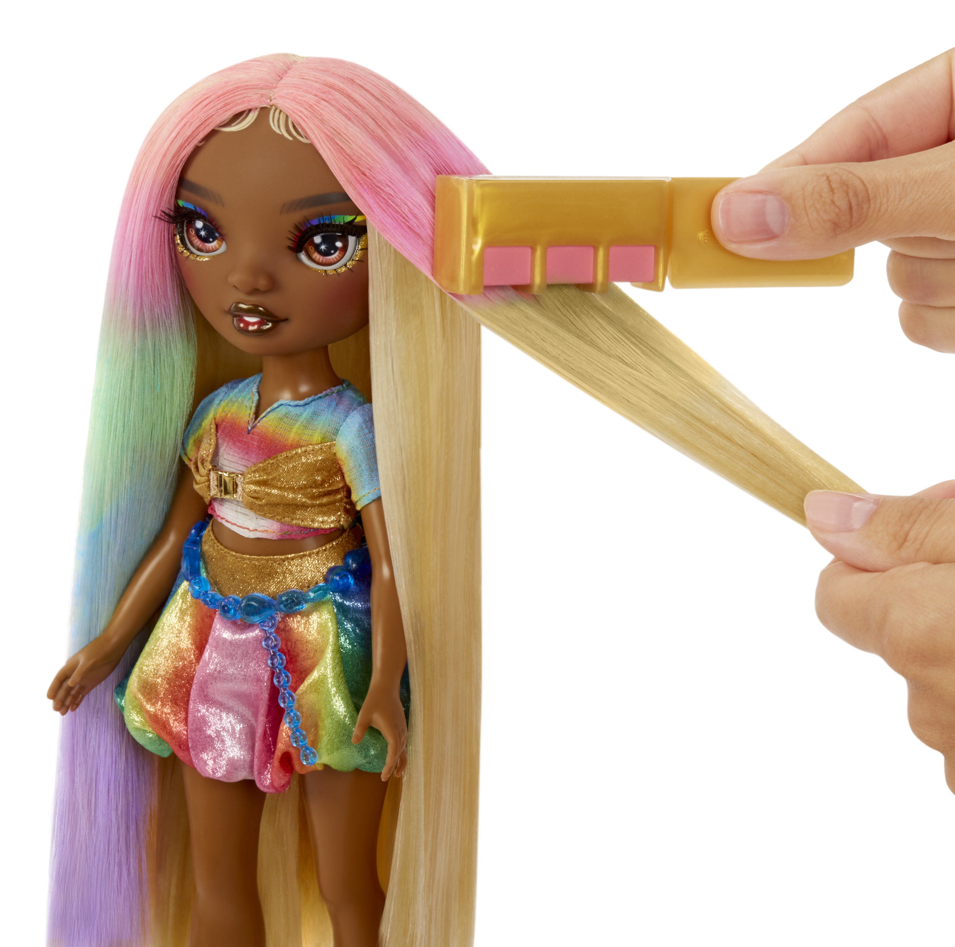 Lalka z tęczowymi włosami, która jest stylizowana. Złoty grzebień jest we włosach lalki.