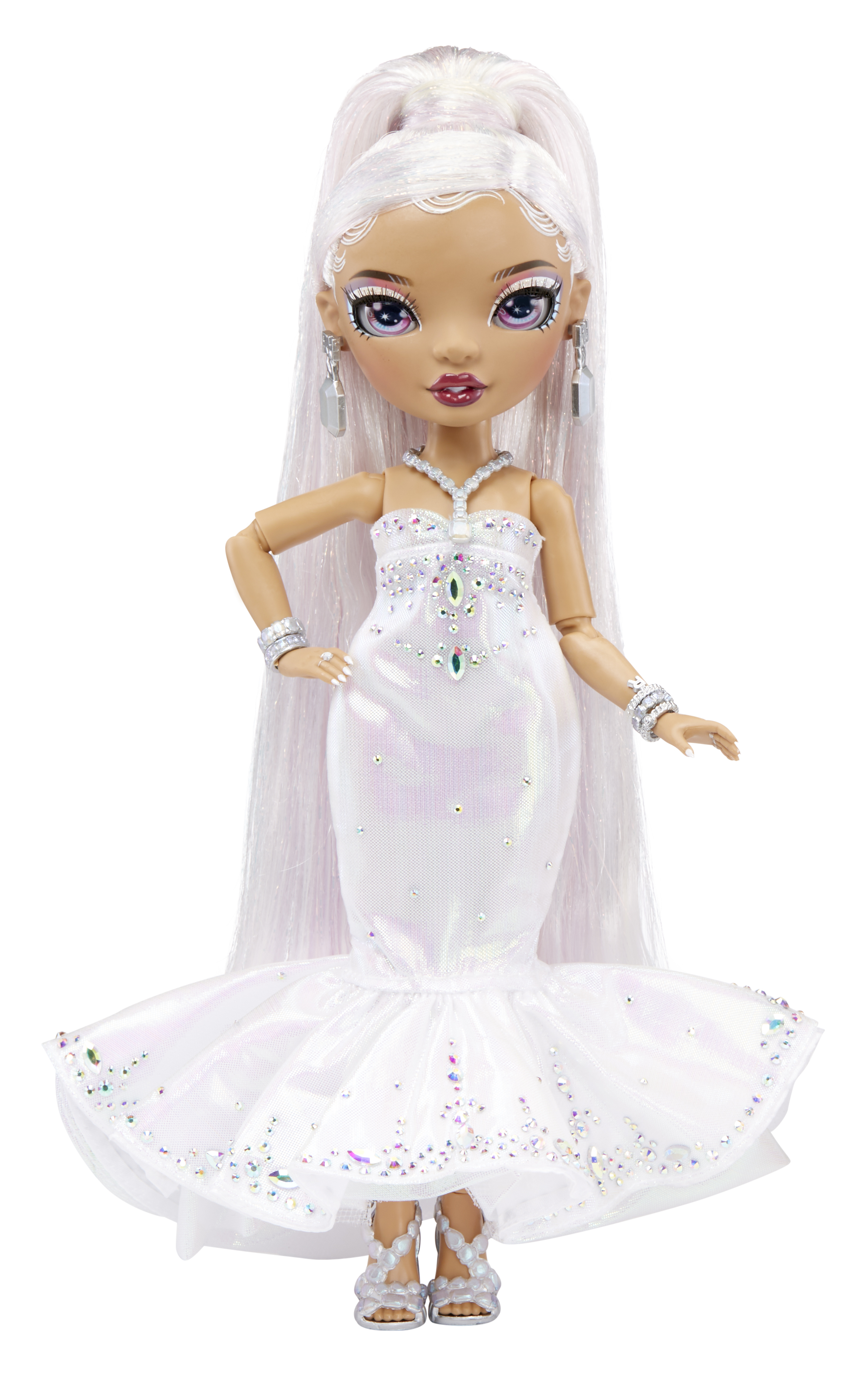 Lalka z długimi białymi włosami, białą suknią i srebrnymi dodatkami stoi na białej powierzchni.