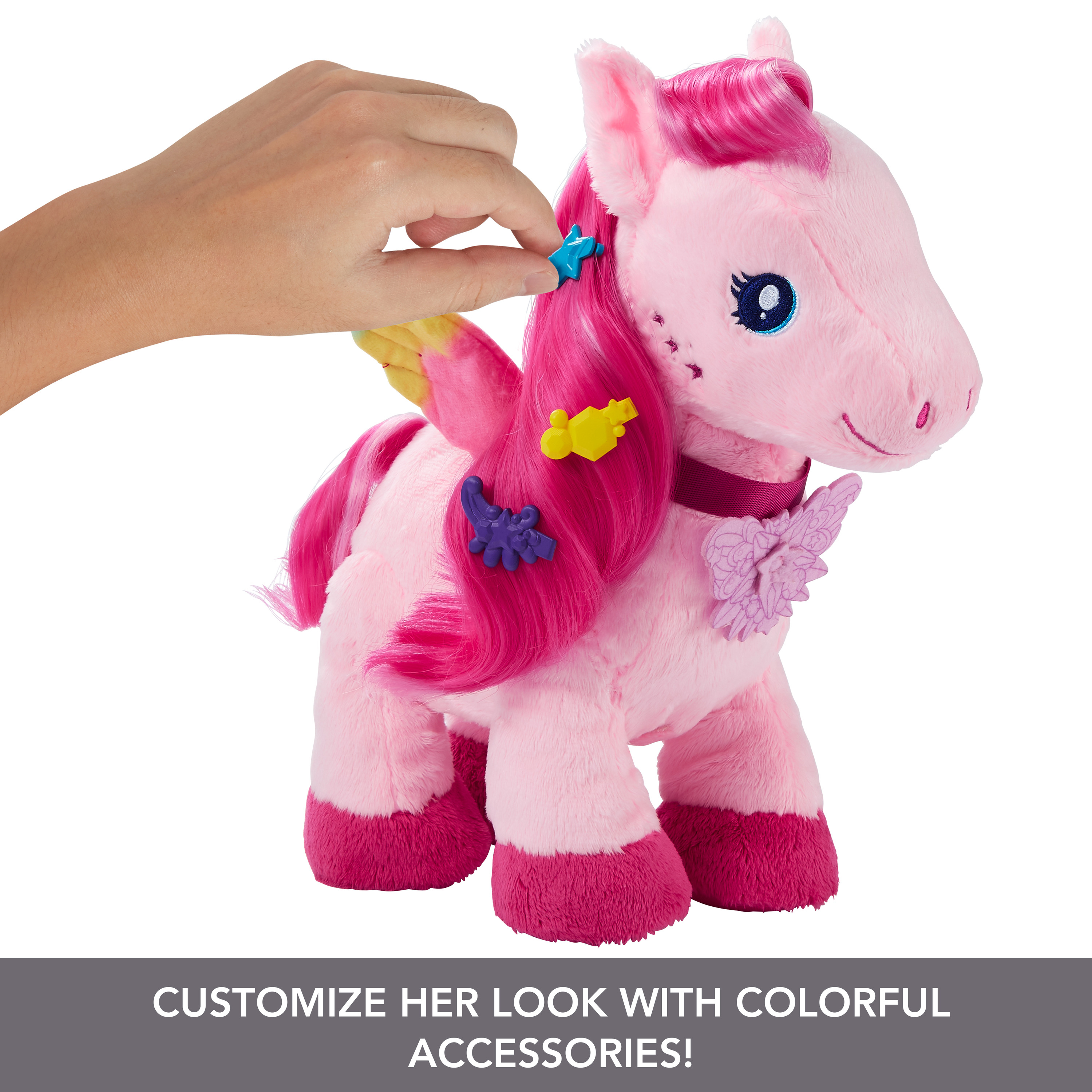 Rosa Plüsch-Einhorn mit Zubehör wird von einer Hand gestylt. Das Bild hat einen anpassbaren Look und farbenfrohes Zubehör auf weißem Hintergrund.