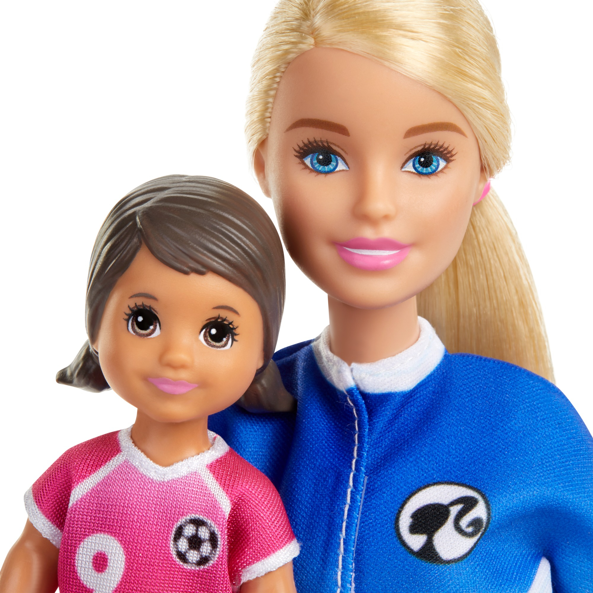 Zwei Barbie-Puppen: Erwachsene und Kind. Die Erwachsene trägt eine blaue Jacke; das Kind trägt ein rosa Fußballtrikot.