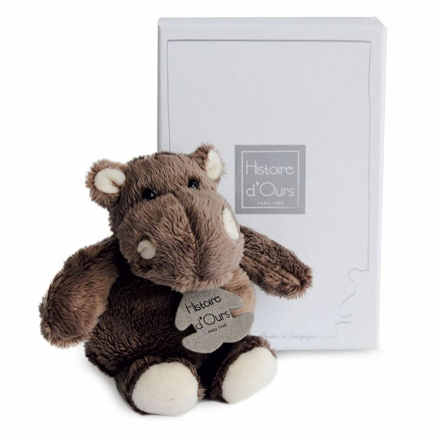 Brązowa pluszowa hipopotam z białą metką i białym pudełkiem w tle. Marka Histoire d'Ours.