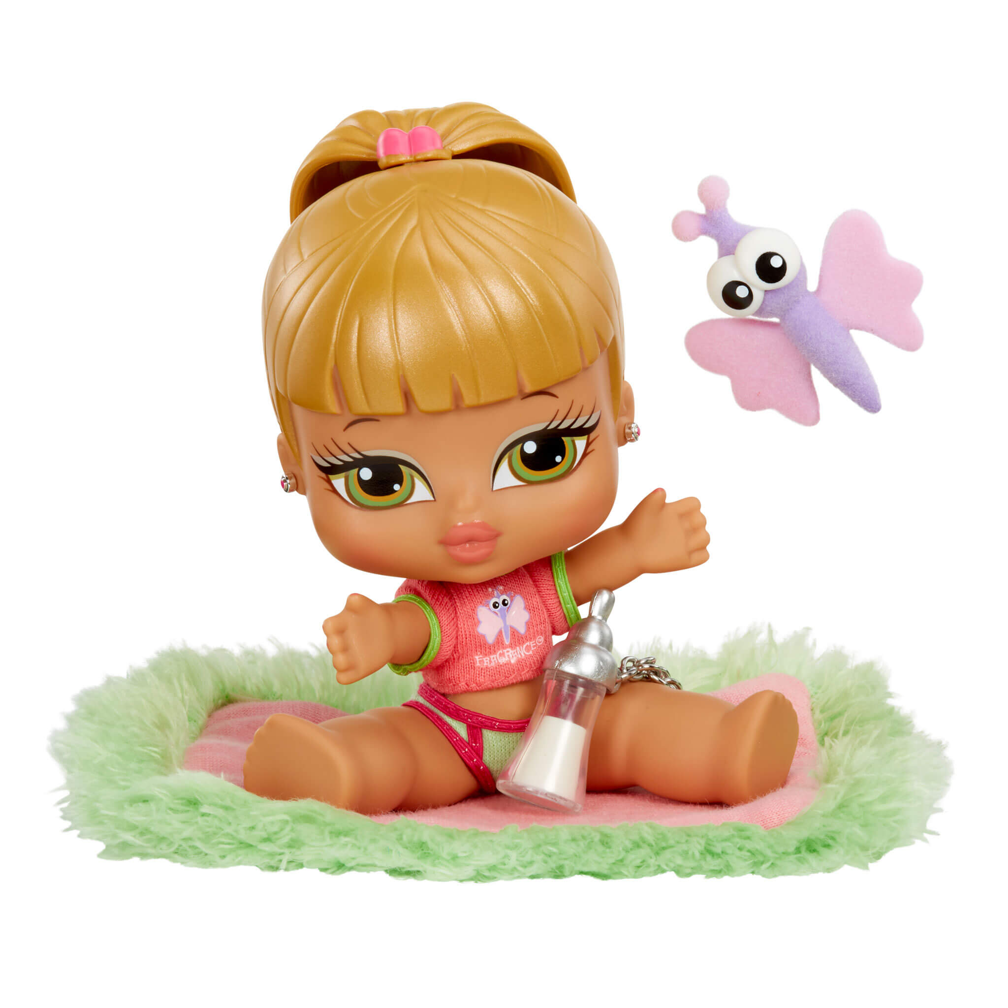 Eine Baby-Bratz-Puppe sitzt auf einem grünen Teppich mit einem Schmetterling und einer Flasche.